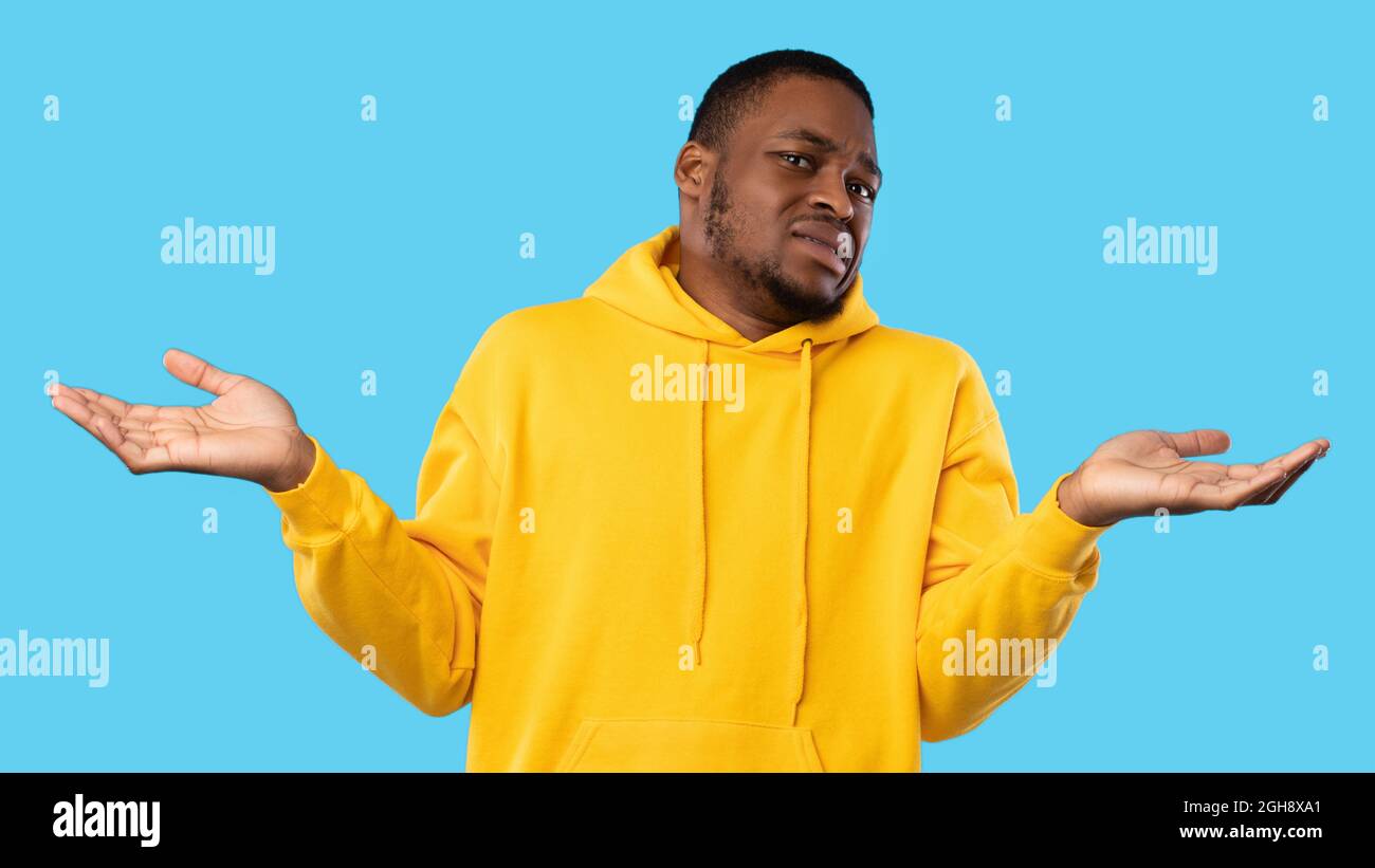 Angewiderter Afroamerikanischer Kerl Zuckend Schultern Posiert Über Blauem Hintergrund Stockfoto