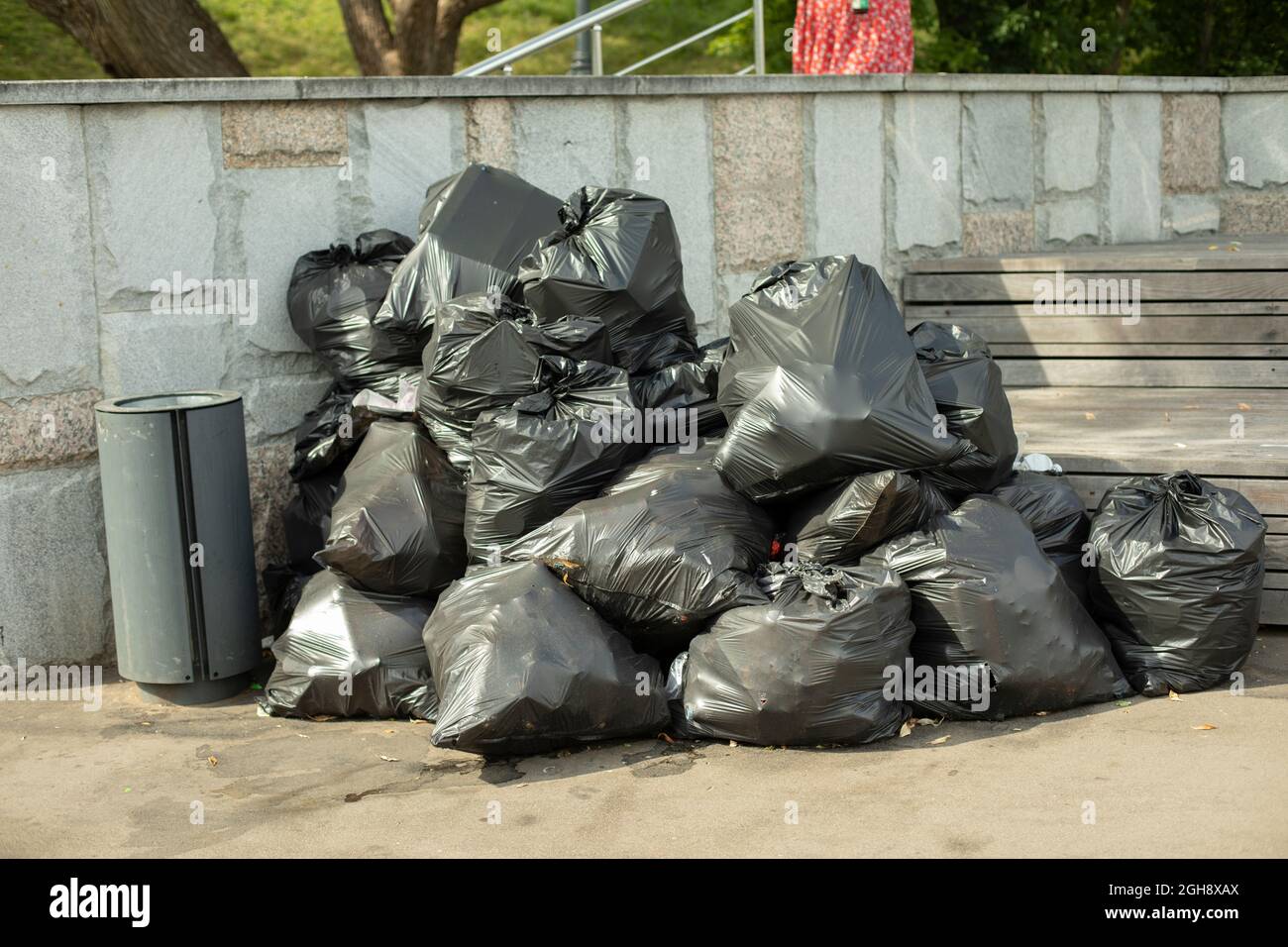 Müllsäcke auf der Straße. Schwarze Abfallbeutel. Plastiktüten mit Hausmüll im Park gesammelt. Viele Säcke stapeln sich im Müllhaufen. Stockfoto