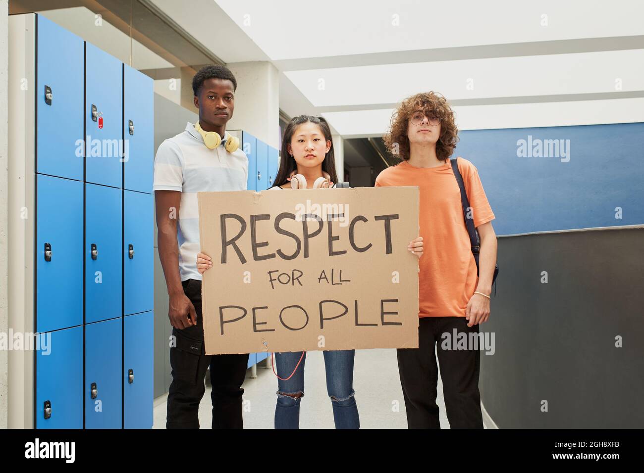 Multiethnische Gruppe von Studenten, die ein Banner tragen, auf dem der Satz geschrieben steht: Respekt für alle Menschen. Teenager, der für Rechte demonstriert. Stockfoto