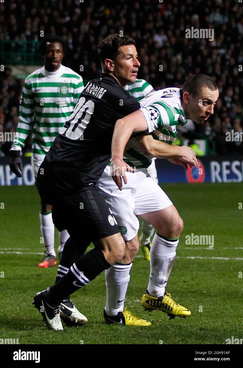 Scott Brown (R) von Celtic wird am 12. Februar 2013 im Celtic Park Stadium in Glasgow, Schottland, in einer Ecke während der UEFA Champions League First Knockout Round von sechzehn, dem 1. Beinspiel zwischen Celtic und Juventus, von Simone Padoin von Juventus ausgetragen Stockfoto