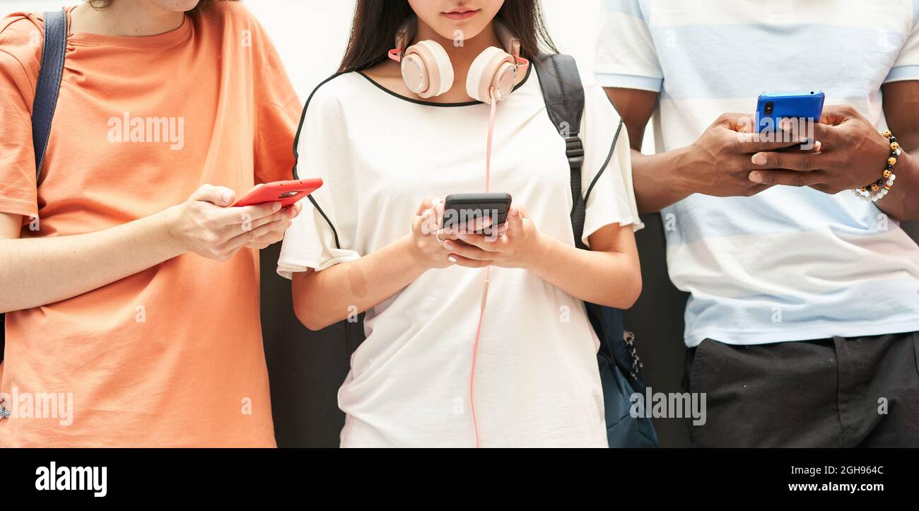 Multiethnische Gruppe von nicht erkennbaren Studenten, die ein Smartphone nutzen. Stockfoto