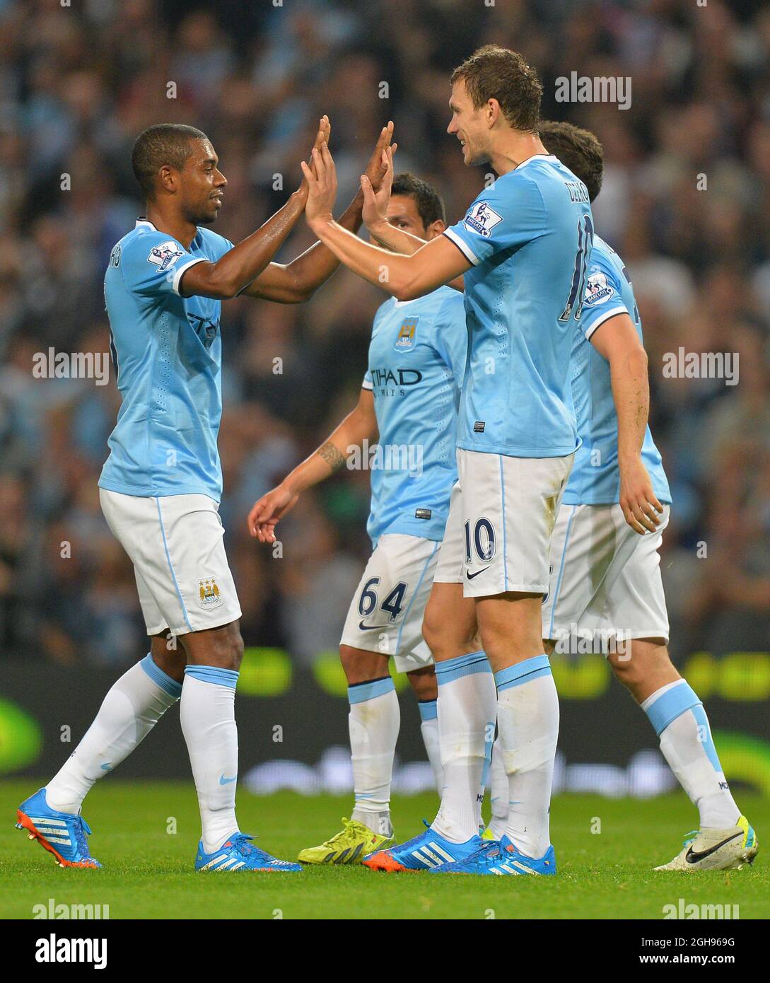 Torschütze Edin Dzeko von Manchester City feiert den ersten Torstand mit Provider Fernandinho von Manchester City während des Capital One Cup, der dritten Runde zwischen Manchester City und Wigan Athletic am 24. September 2013 im Etihad Stadium in Manchester. Stockfoto