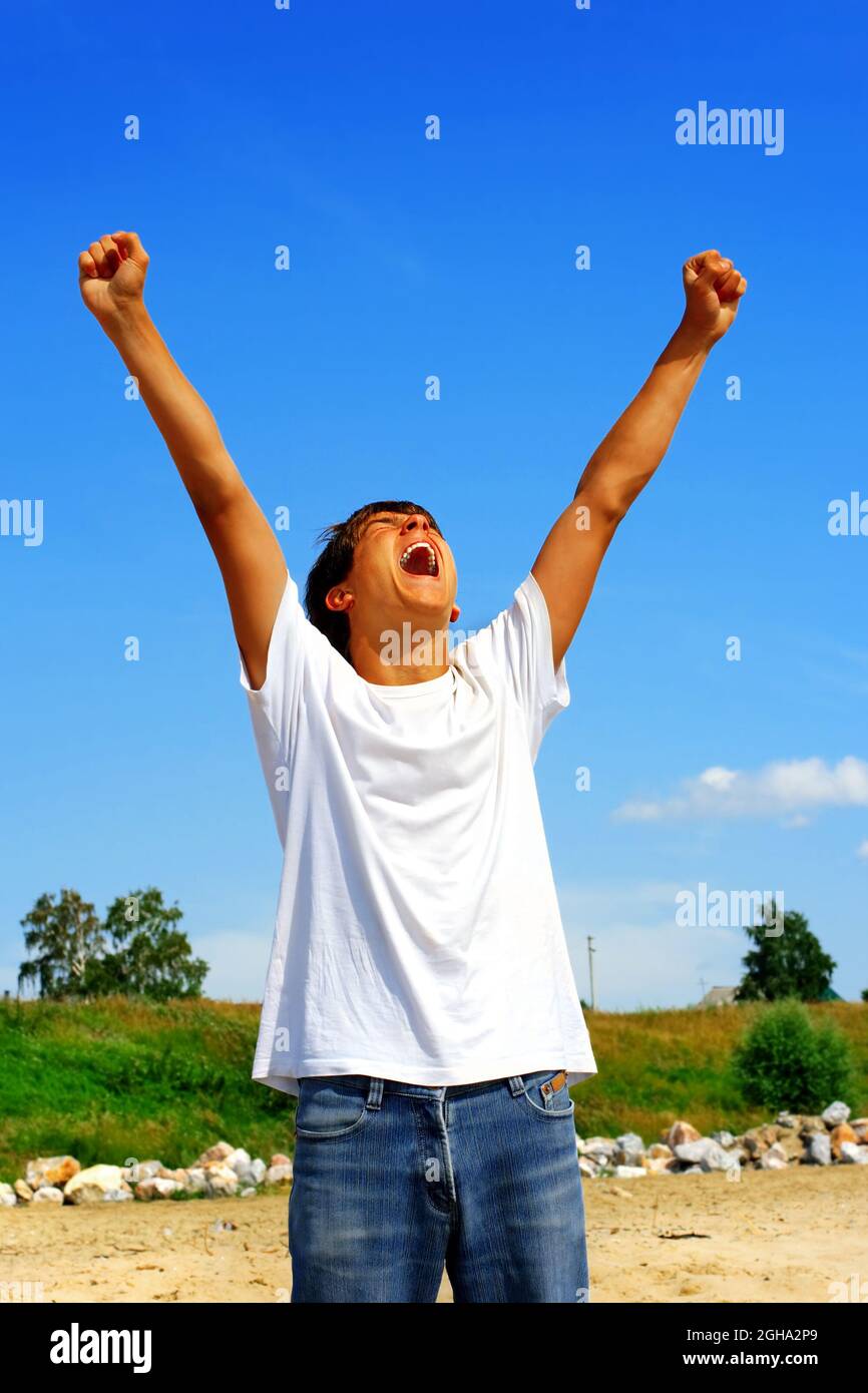 Erfolgreicher junger Mann mit hochhändiges Händchen beim Sommertag im Freien Stockfoto