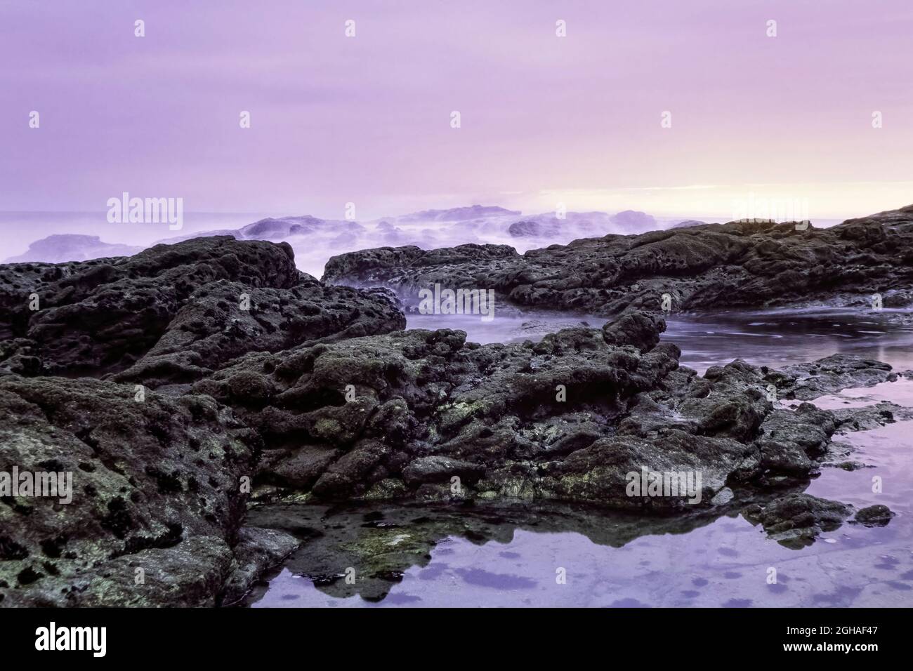 Lange Belichtung in einem portugiesischen felsigen Strand in der Abenddämmerung. Analog: 35-mm-Dia Film. Stockfoto