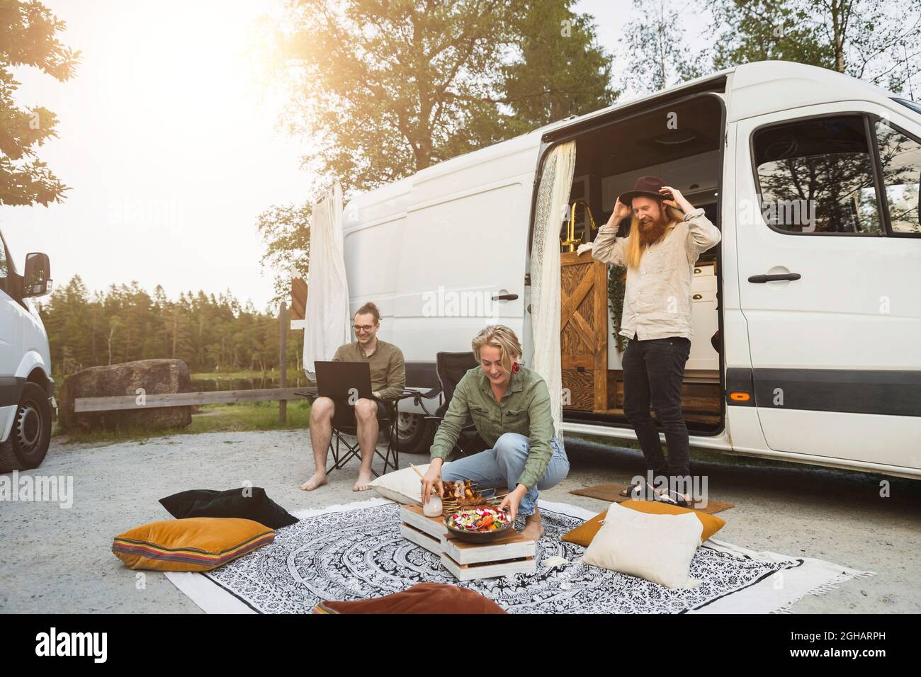 Frau, die abends vor dem Campingbus Essen zubereitete Stockfoto