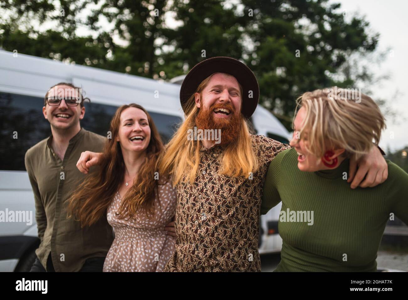 Fröhliche Freunde mit den Armen, die durch das Wohnheim laufen Stockfoto