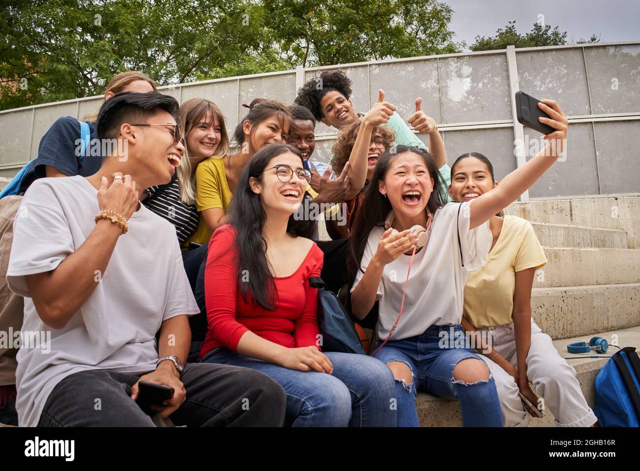 Gruppe von multirassischen Studenten, die Selfies mit dem Mobiltelefon machen. Klassenkameraden zusammen Spaß haben. Stockfoto