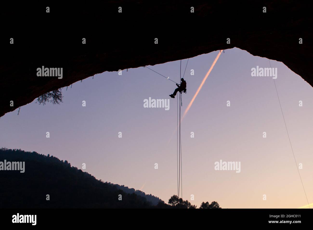 Silhouette eines Kletterers, der in der Höhle hängt. Klettern in spanien. Stockfoto