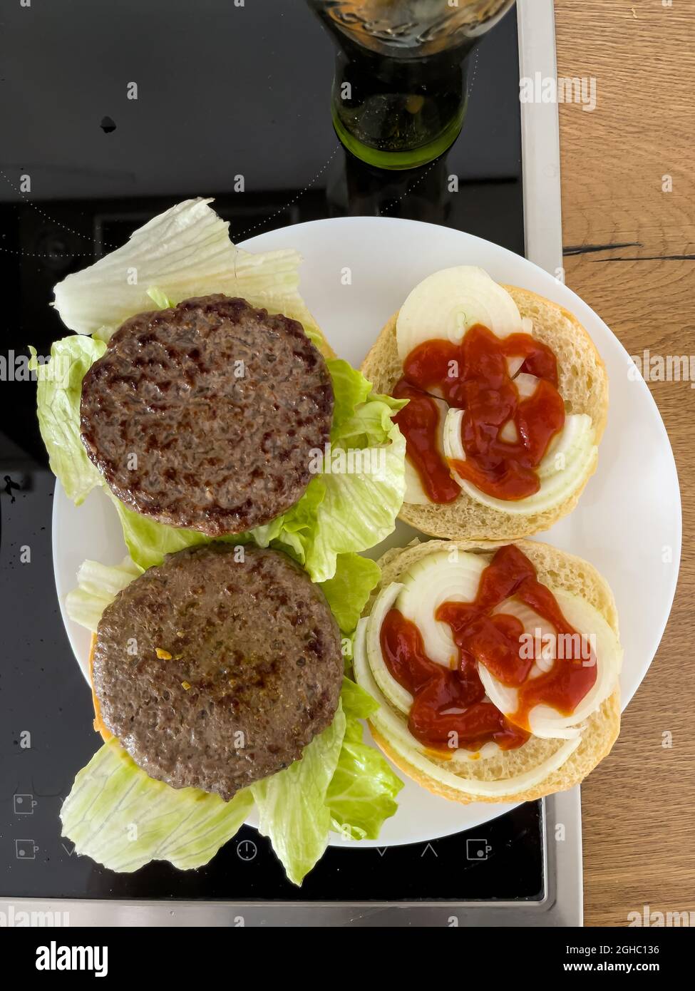 Blick von oben auf ein frisch verzehrfertiges, gebratenes Paar Hamburger, leckere zubereitete Speisen von zu Hause. Stockfoto