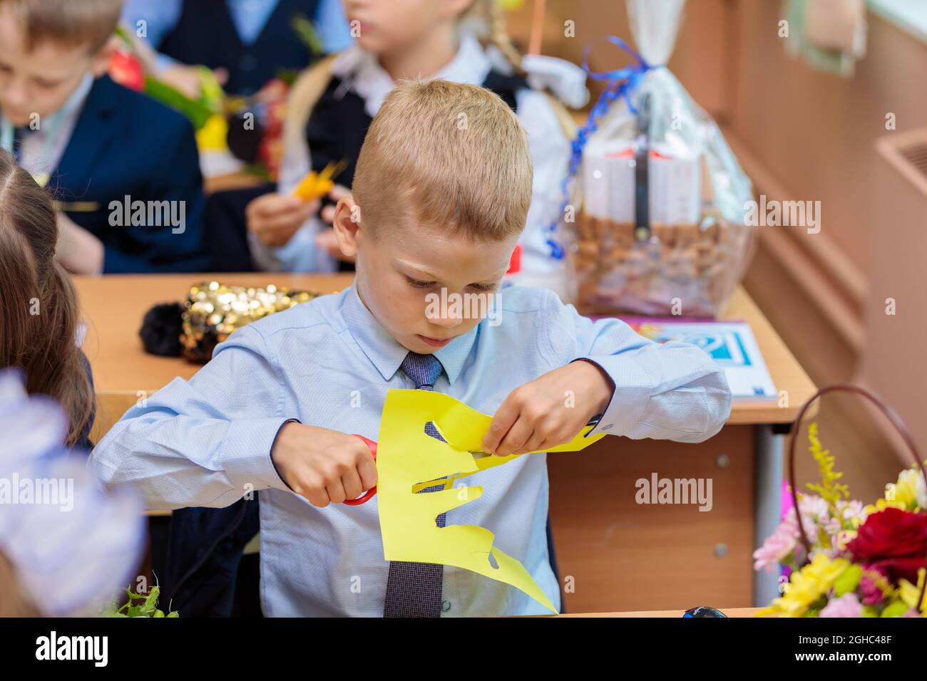 Erstklässler in der Lektion schneiden Zahlen für Anwendungen aus Papier aus. Schule, Wissenstag. Moskau, Russland, 1. September 2021 Stockfoto
