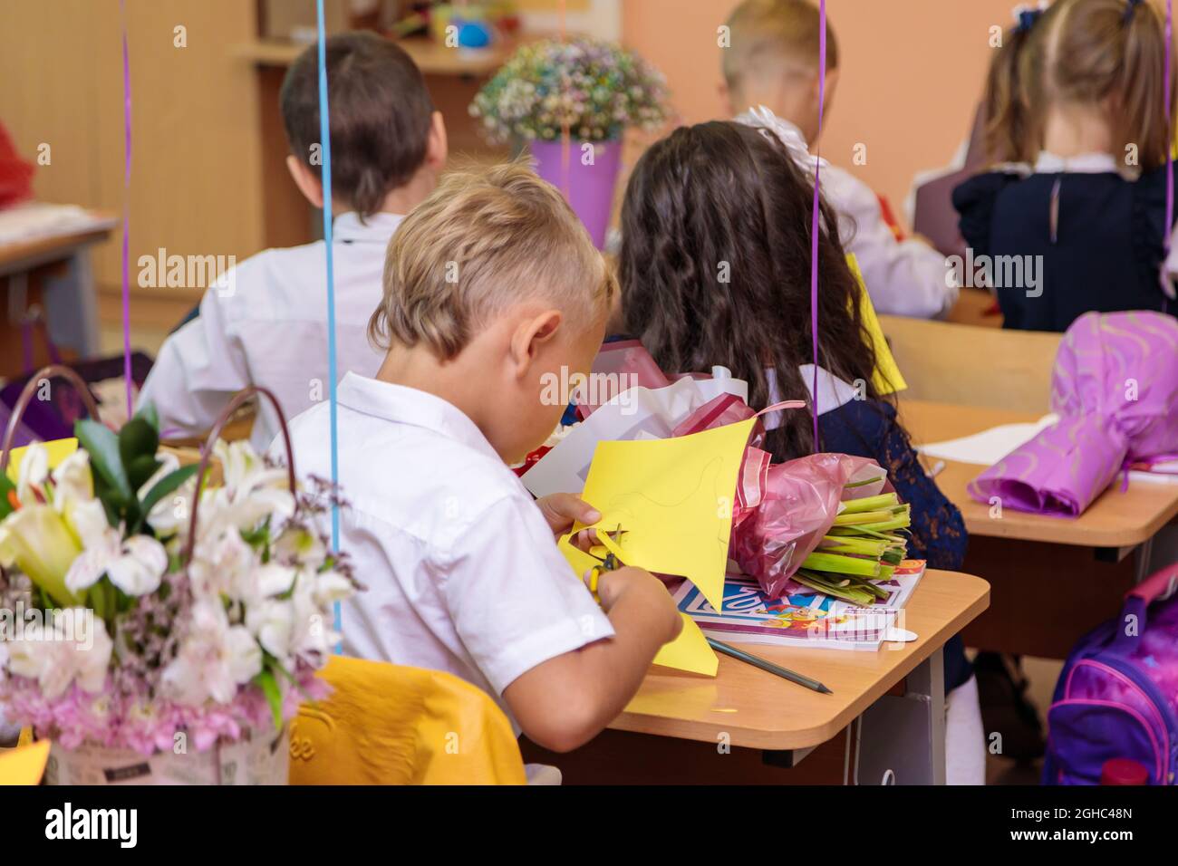 Erstklässler in der Lektion schneiden Zahlen für Anwendungen aus Papier aus. Schule, Wissenstag. Moskau, Russland, 1. September 2021 Stockfoto
