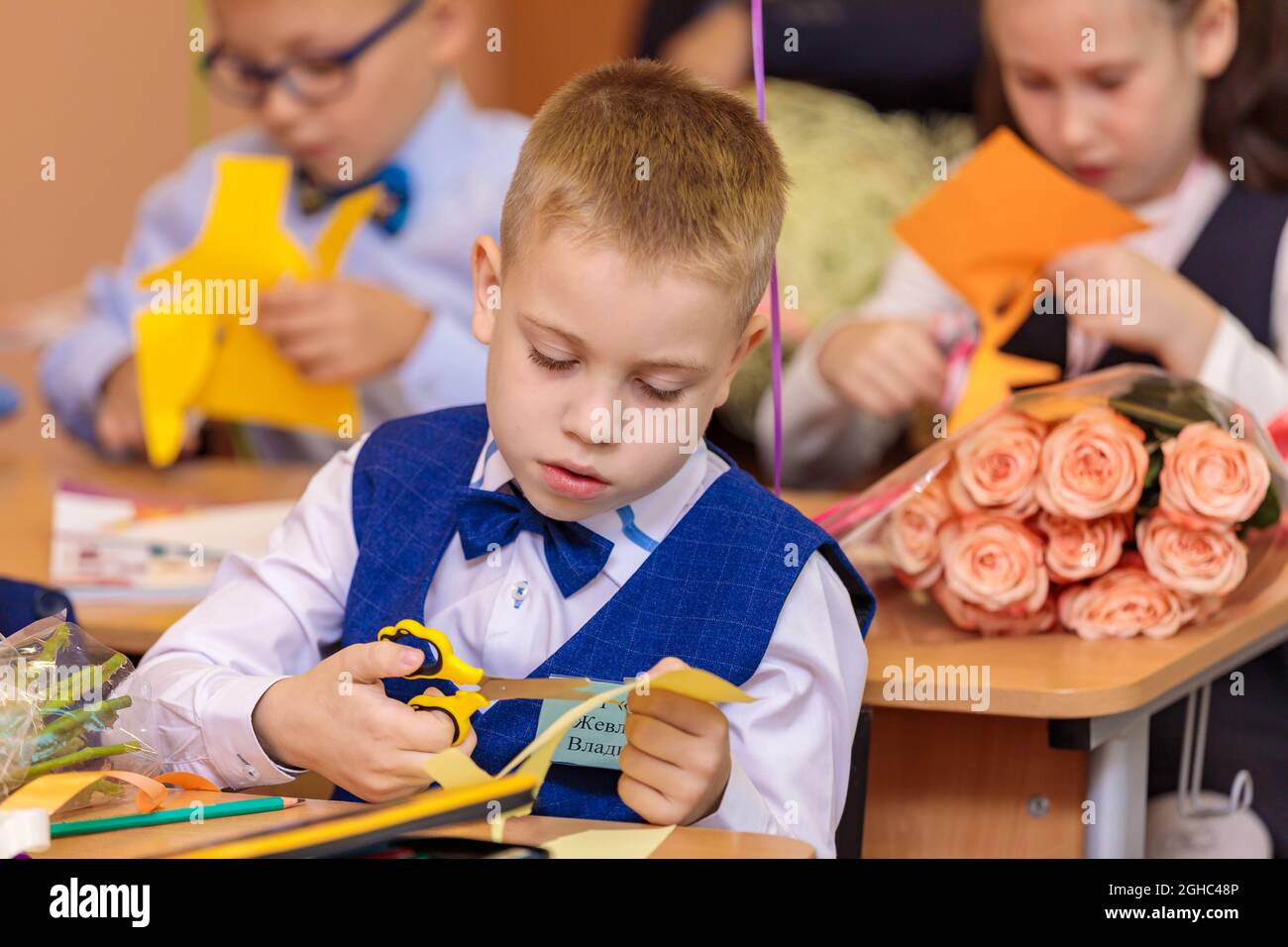 Erstklässler in der Lektion schneiden Zahlen für Anwendungen aus Papier aus. Schule, Wissenstag. Moskau, Russland, 1. September 2021 Stockfoto