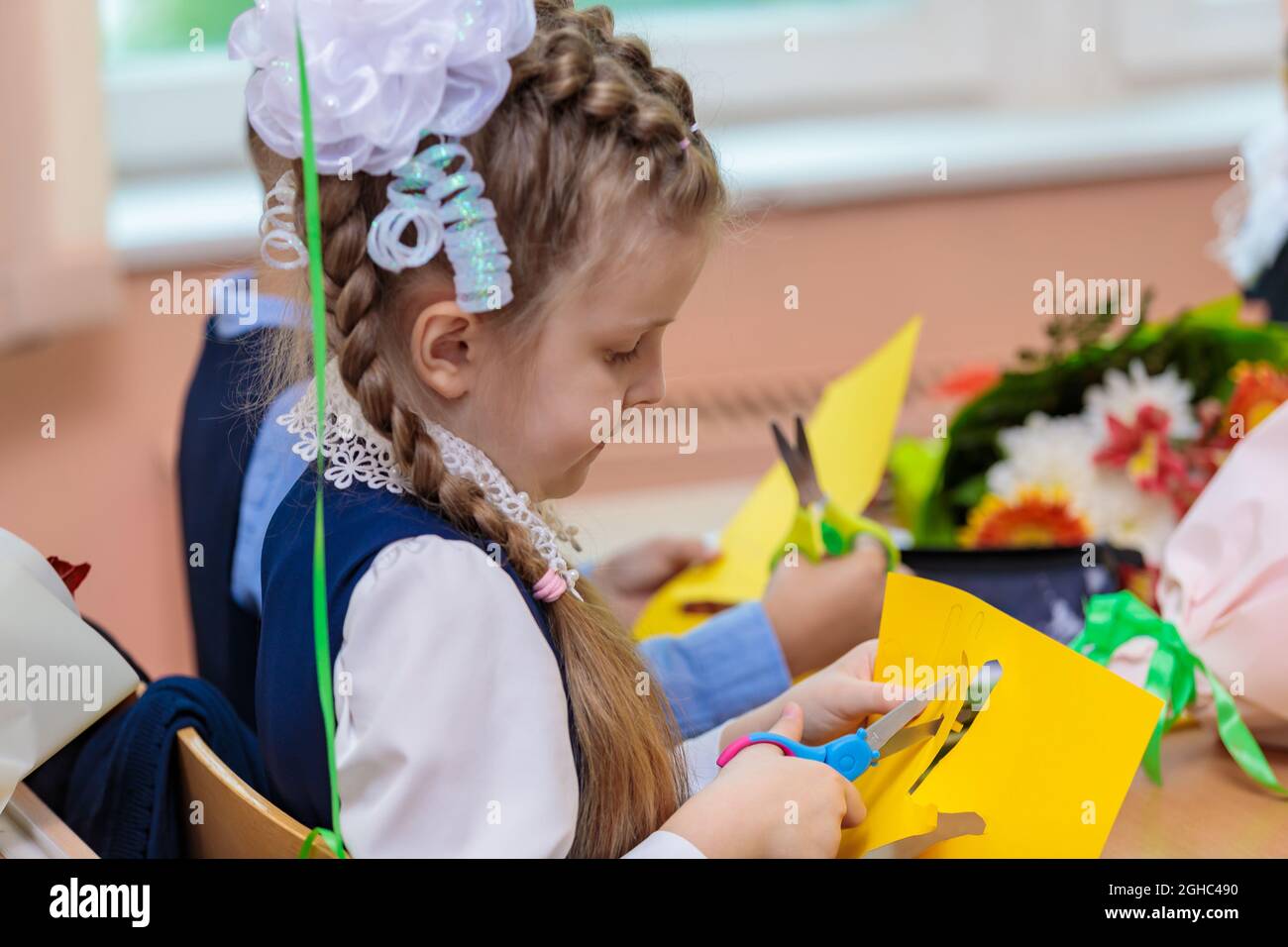 Erstklässler in der Lektion schneiden Zahlen für Anwendungen aus Papier aus. Schule, Wissenstag. Moskau, Russland, 1. September 2021 Stockfoto