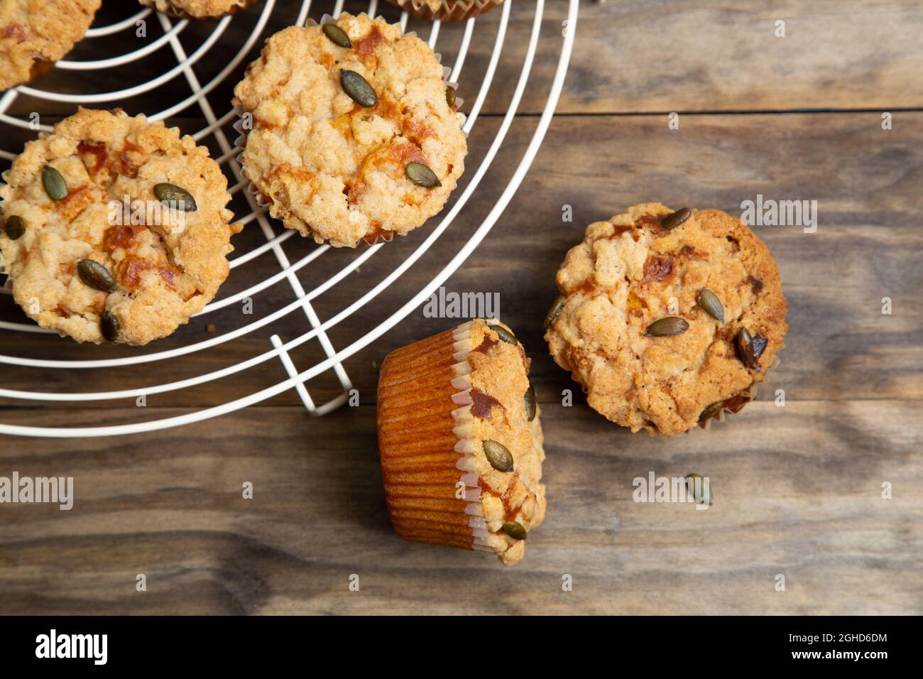 Kürbismuffins mit Krümel und Samen auf einem rustikalen Holztisch Stockfoto