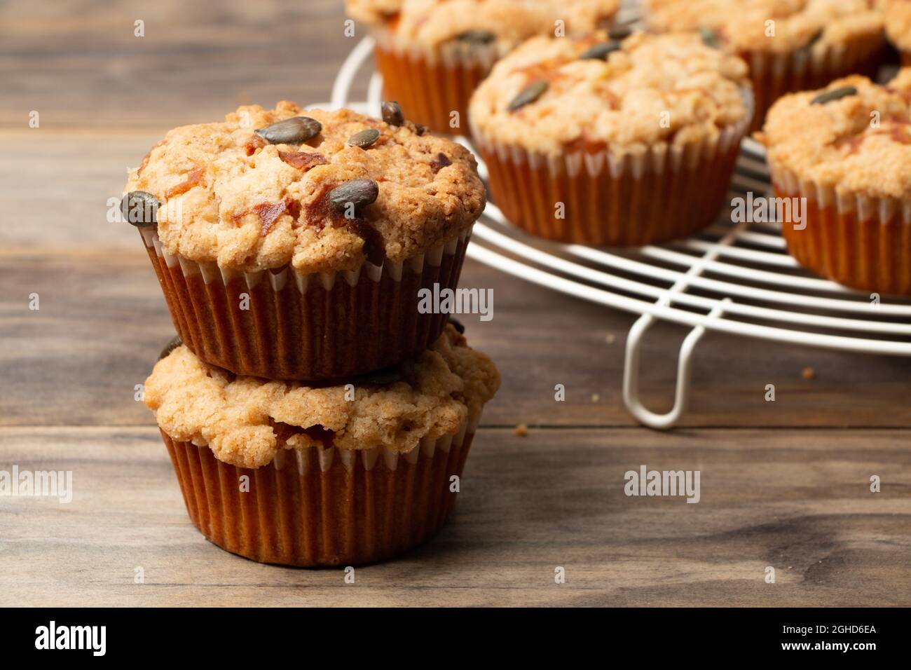 Kürbismuffins mit Krümel und Samen auf einem rustikalen Holztisch Stockfoto