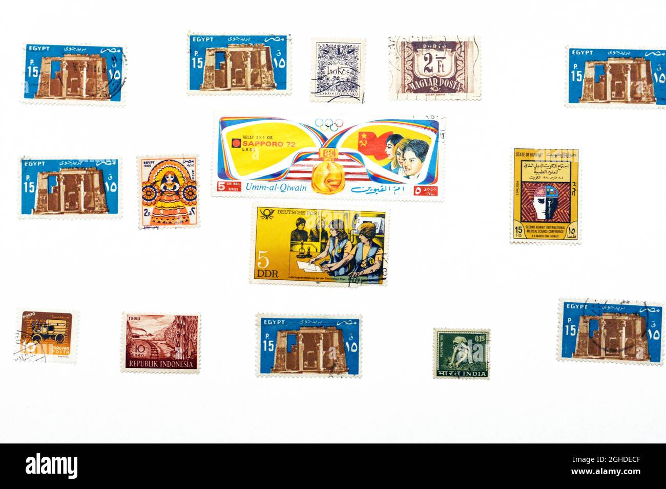 Hintergrund von verschiedenen alten alten Vintage gebrauchten Briefmarken aus verschiedenen Ländern und Zeiten auf weißem Hintergrund, ein Umschlag mit einer Reihe von Briefmarken Stockfoto