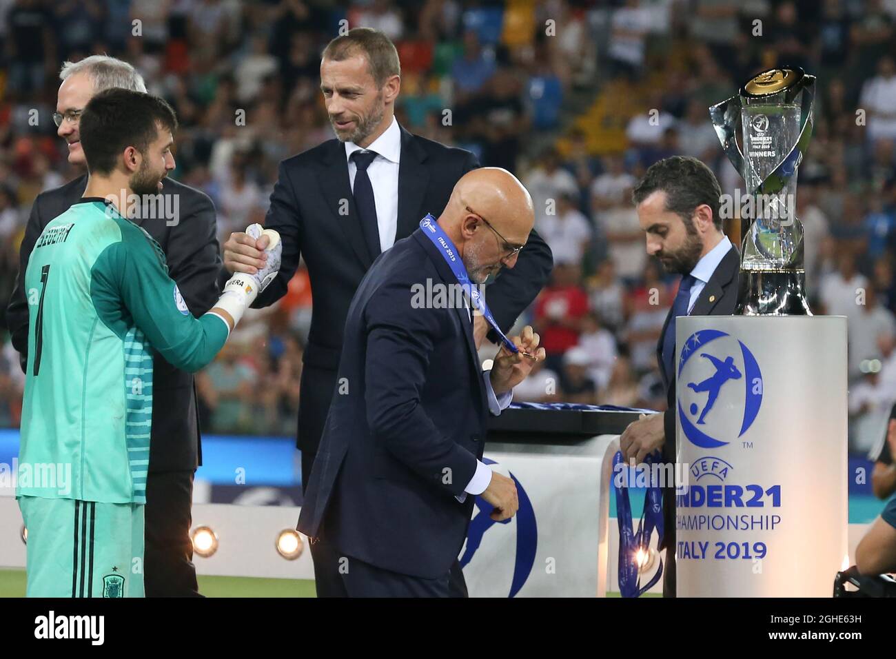 Luis de la Fuente, der spanische Manager, blickt auf die Siegermedaille, als Antonio Sivera während des UEFA-U-21-Meisterschaftsspiel im Stadio Friuli die Hände mit dem UEFA-Vorsitzenden Aleksander Ceferin schüttelt. Bilddatum: 30. Juni 2019. Bildnachweis sollte lauten: Jonathan Moscrop/Sportimage via PA Images Stockfoto