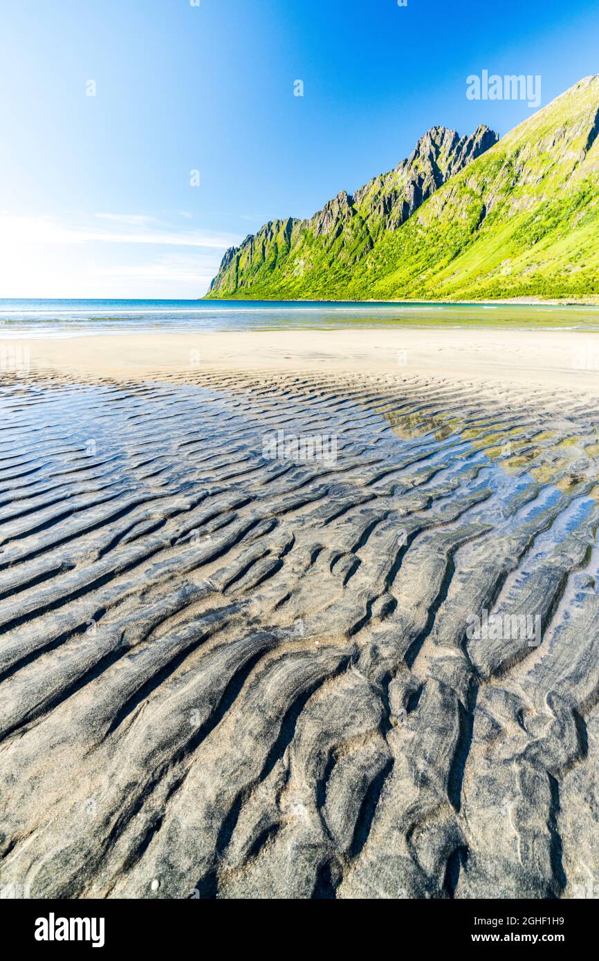 Transparentes Wasser des arktischen Meeres, das den weißen Sand des Ersfjord-Strandes, Senja, Grafschaft Troms, Norwegen, spült Stockfoto