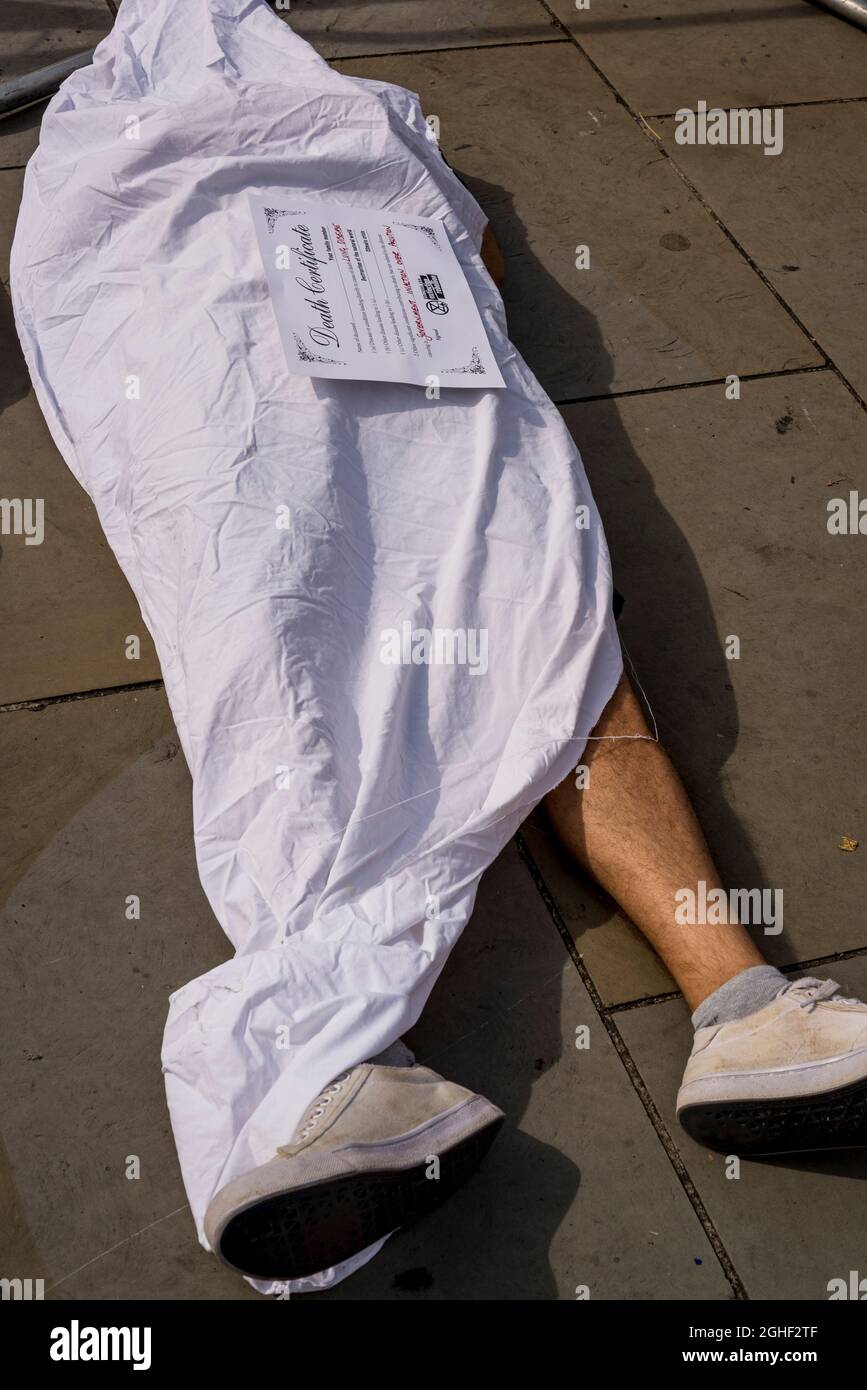 Die Rebellion des Aussterbens Sterben aus Protest vor dem Parlamentsgebäude mit Demonstranten, die mit weißem Laken bedeckt sind und mit Zeichen, die die Todesursachen des Klimawandels wie Hunger, Ertrinken, Umweltverschmutzung und Cholera, Parliament Square, London, GROSSBRITANNIEN 06.09.2021 Stockfoto