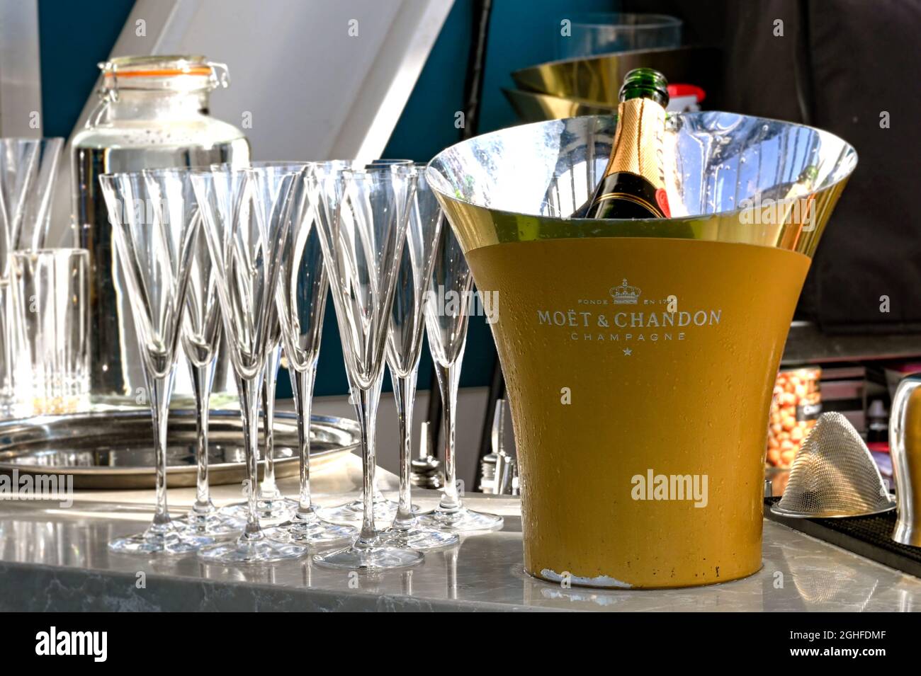 London, England - August 2021: Eiskübel mit einer Flasche Moet et Chandon Champagner und leeren Gläsern. Stockfoto