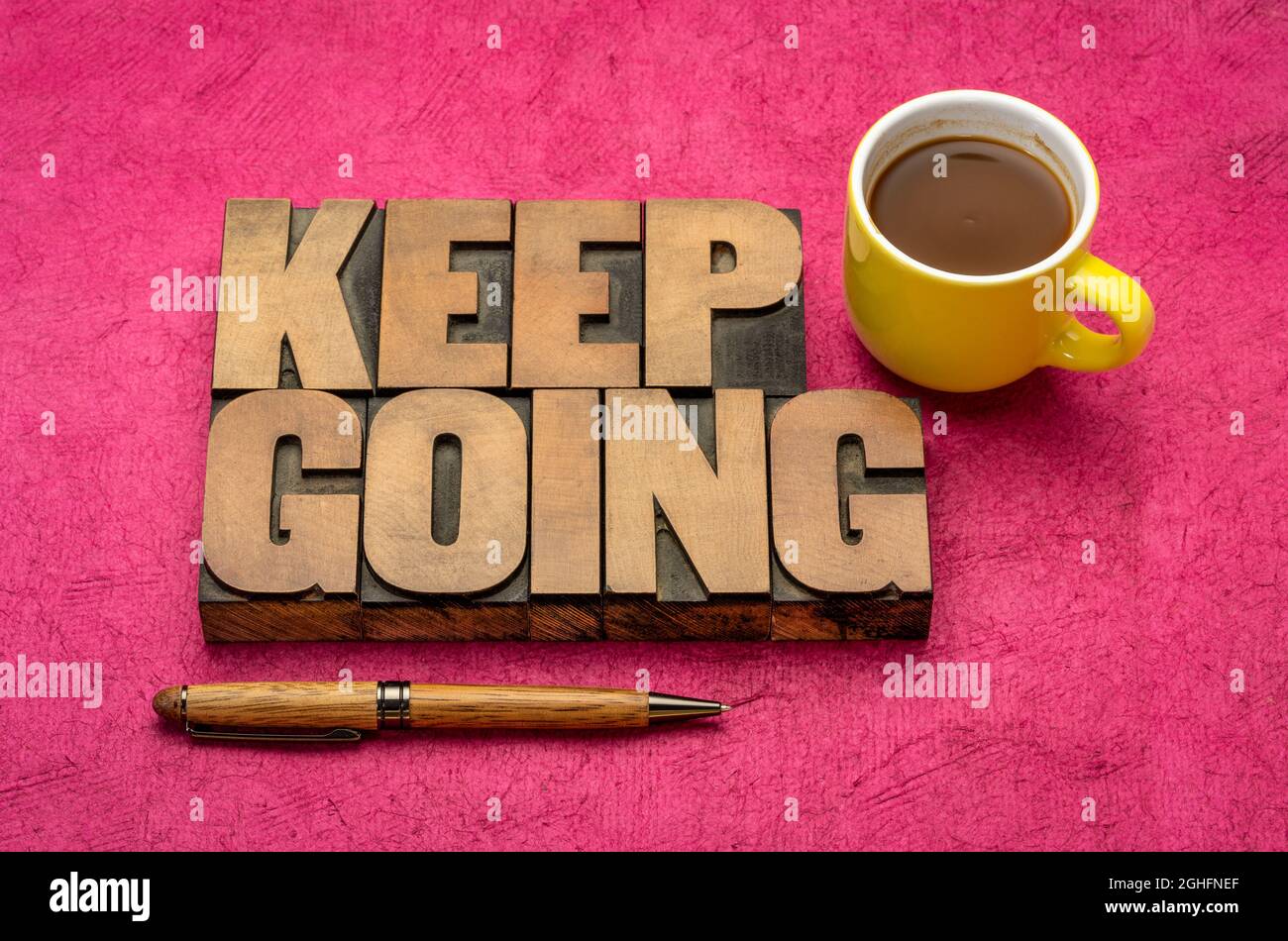 Keep Going Motivation Wort abstrakt in Vintage-Buchdruck Holzklötze mit einer Tasse Kaffee, Entschlossenheit, Ausdauer und Zähigkeit Konzept Stockfoto