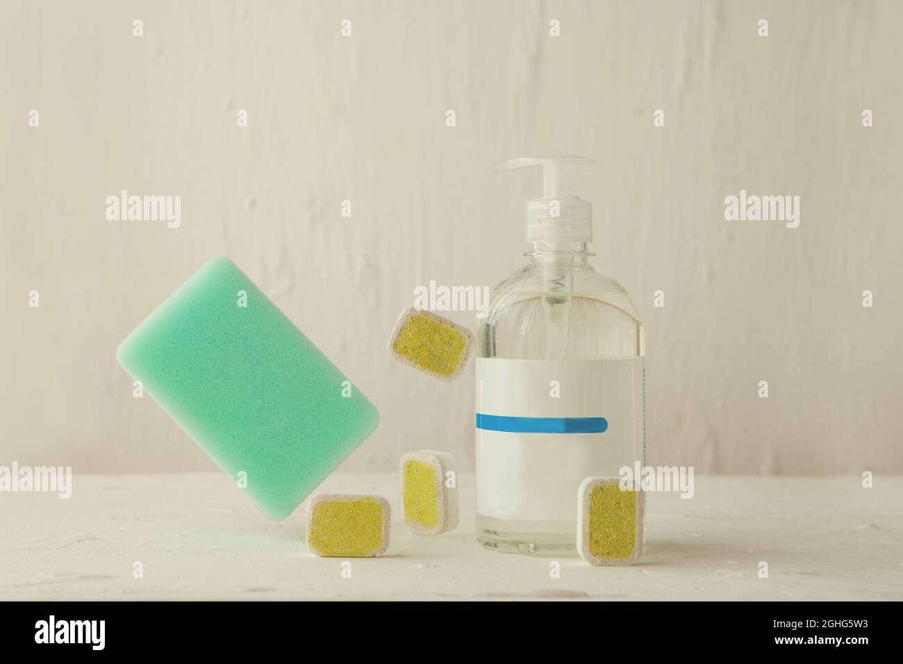 Spülmaschinen-Tabs zur Reinigung mit Schwamm. Waschtabletten und Flüssigkeit im Schwebegang Stockfoto