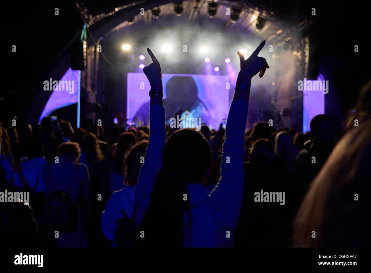 Menschenmenge im Club. Viele Leute beim Konzert. Silhouetten von Menschen auf dem Hintergrund der Bühne Stockfoto