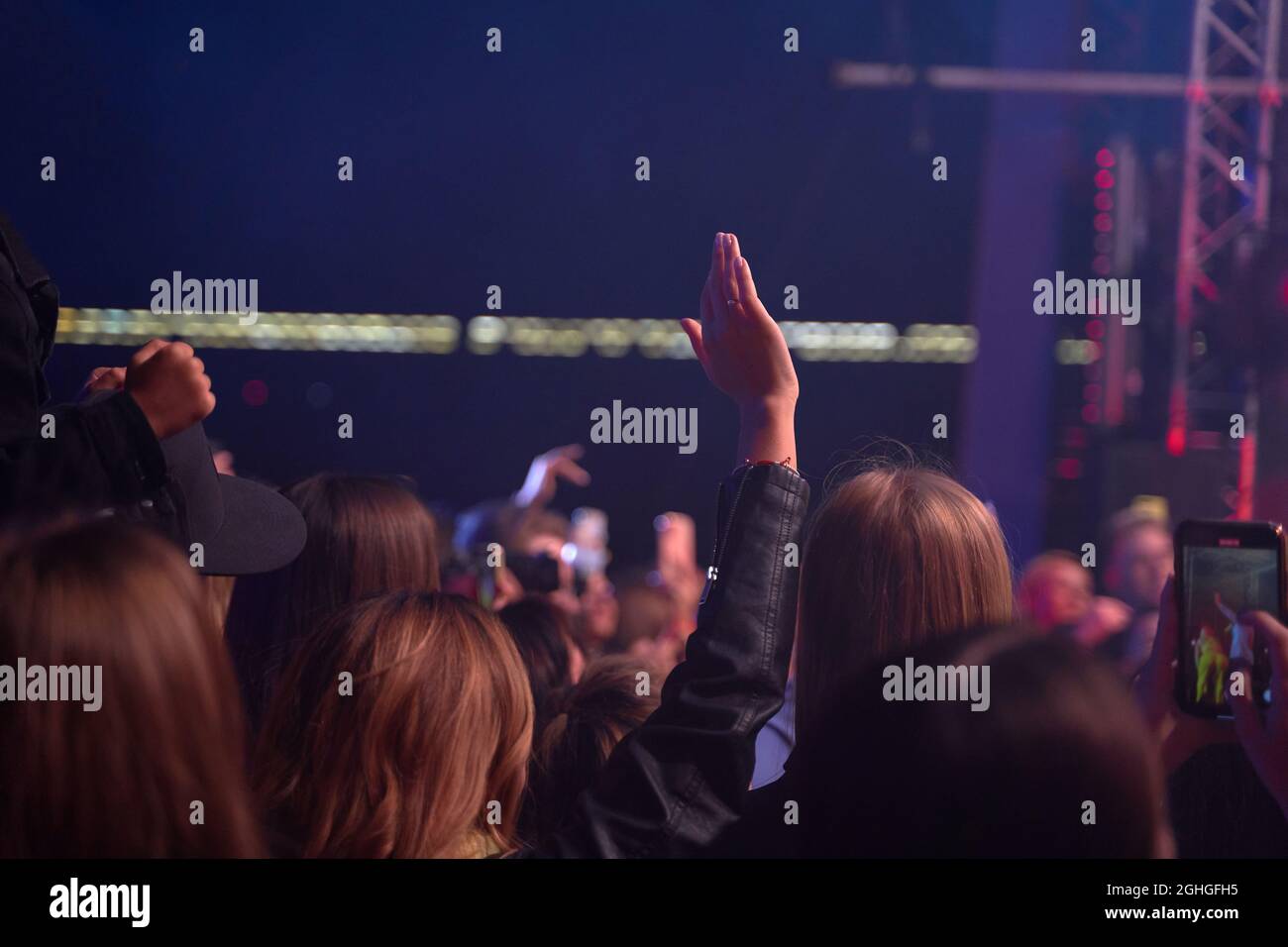 Menschenmenge im Club. Viele Leute beim Konzert. Silhouetten von Menschen auf dem Hintergrund der Bühne Stockfoto