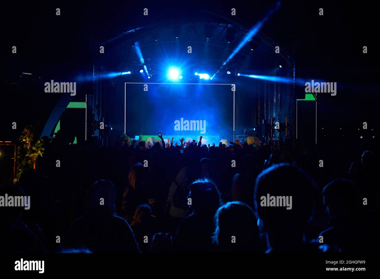 Menschenmenge im Club. Viele Leute beim Konzert. Silhouetten von Menschen auf dem Hintergrund der Bühne Stockfoto