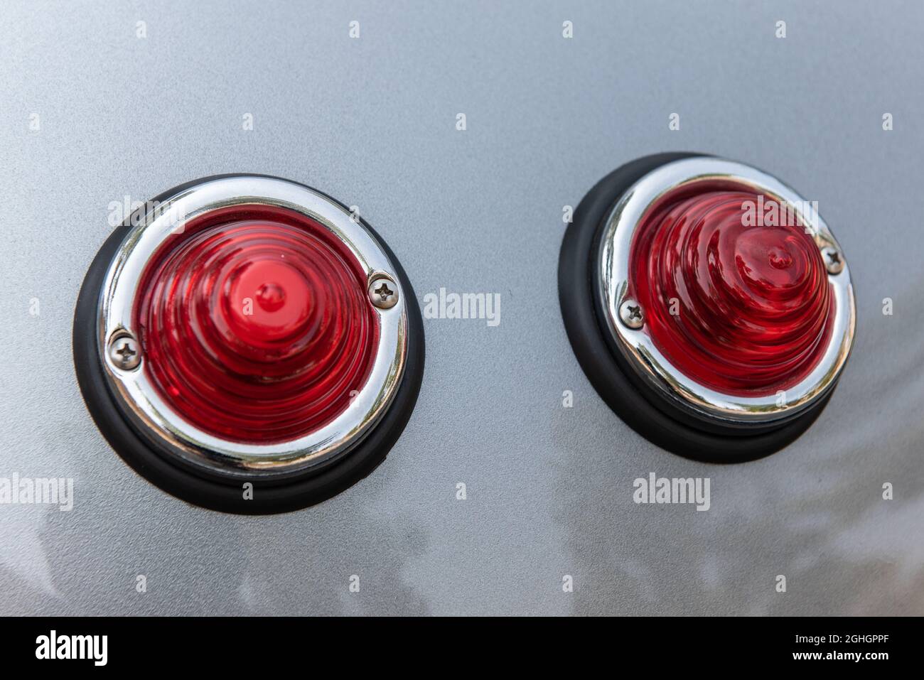 Rückleuchten von Oldtimer-Sportwagen hat runde konusförmige Linsen über den Lampen. Stockfoto
