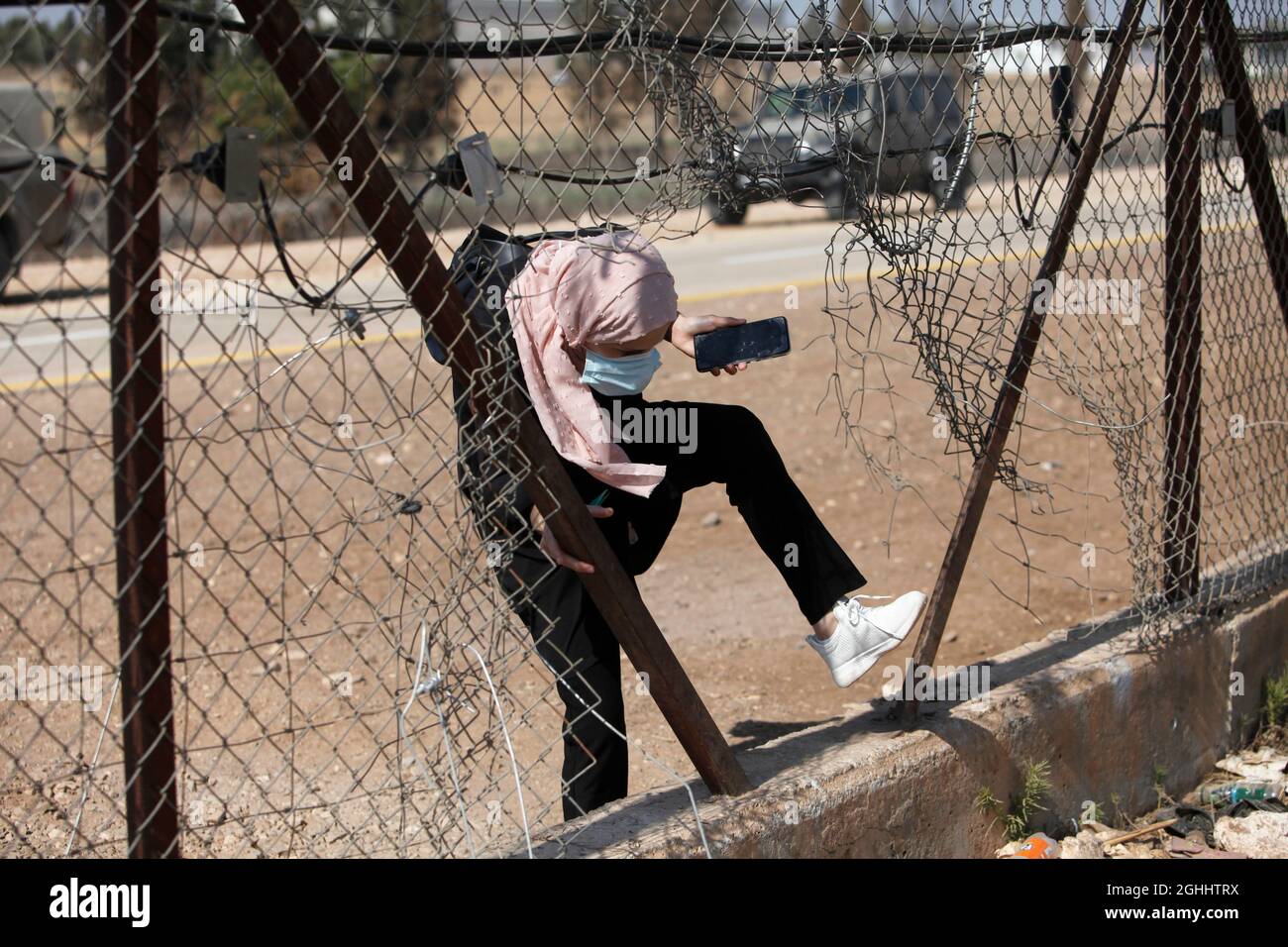 Jenin, Palästina. September 2021. Eine Palästinenserin überquert den beschädigten Abschnitt der israelischen Trennmauer in der Nähe der Stadt Jenin im Westjordanland.sechs palästinensische Gefangene sind am Montag aus dem Gefängnis in Israel geflohen, was zu einer weit verbreiteten Menschenjagd führte, sagten die israelischen Behörden. Die Polizei sagte in einer Erklärung, dass die äußerst seltene Flucht über Nacht im Gilboa Gefängnis stattfand, einem Gefängnis mit maximaler Sicherheit für palästinensische Gefangene in Nordisraelisch. (Foto von Nasser Ishtayeh/SOPA Images/Sipa USA) Quelle: SIPA USA/Alamy Live News Stockfoto