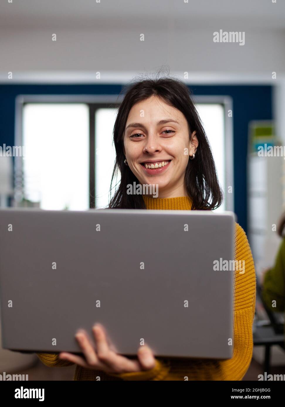 Designerin, die in der Post-Production-Agentur für Design arbeitet, blickt lächelnd auf die Kamera. Videofilmer Grafikeditor steht in Multimedia-Unternehmen mit Laptop Bearbeitung kreative Video Stockfoto