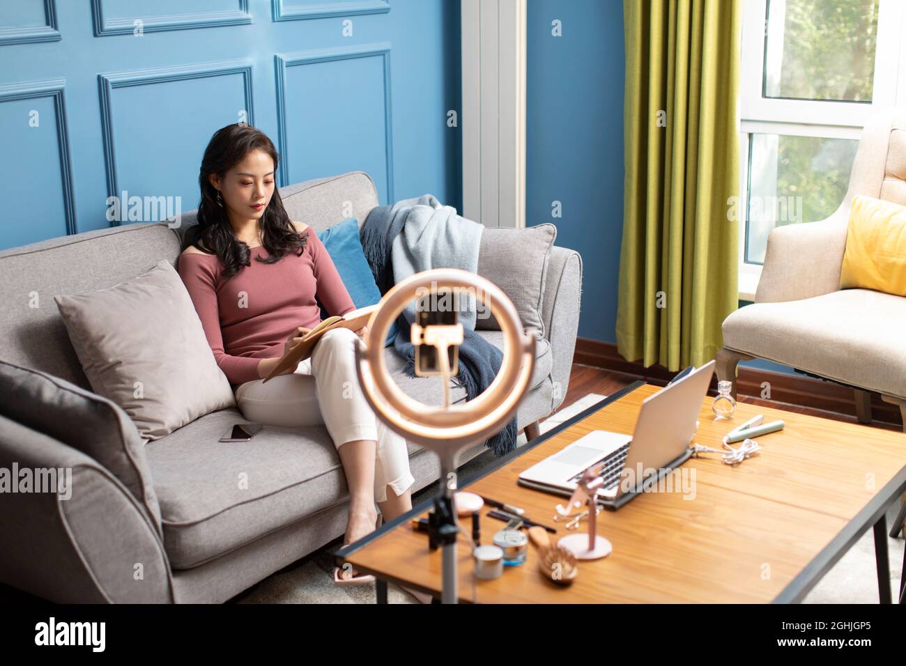 Junge Frau sitzt auf dem sofa Stockfoto