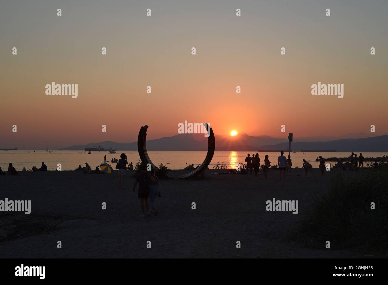 Die Sonne untergeht über der English Bay und eine Silhouette mit dem Namen 217.5 Arc x 3 des französischen Künstlers Bernar Venet am Sunset Beach in Vancouver, British Co Stockfoto