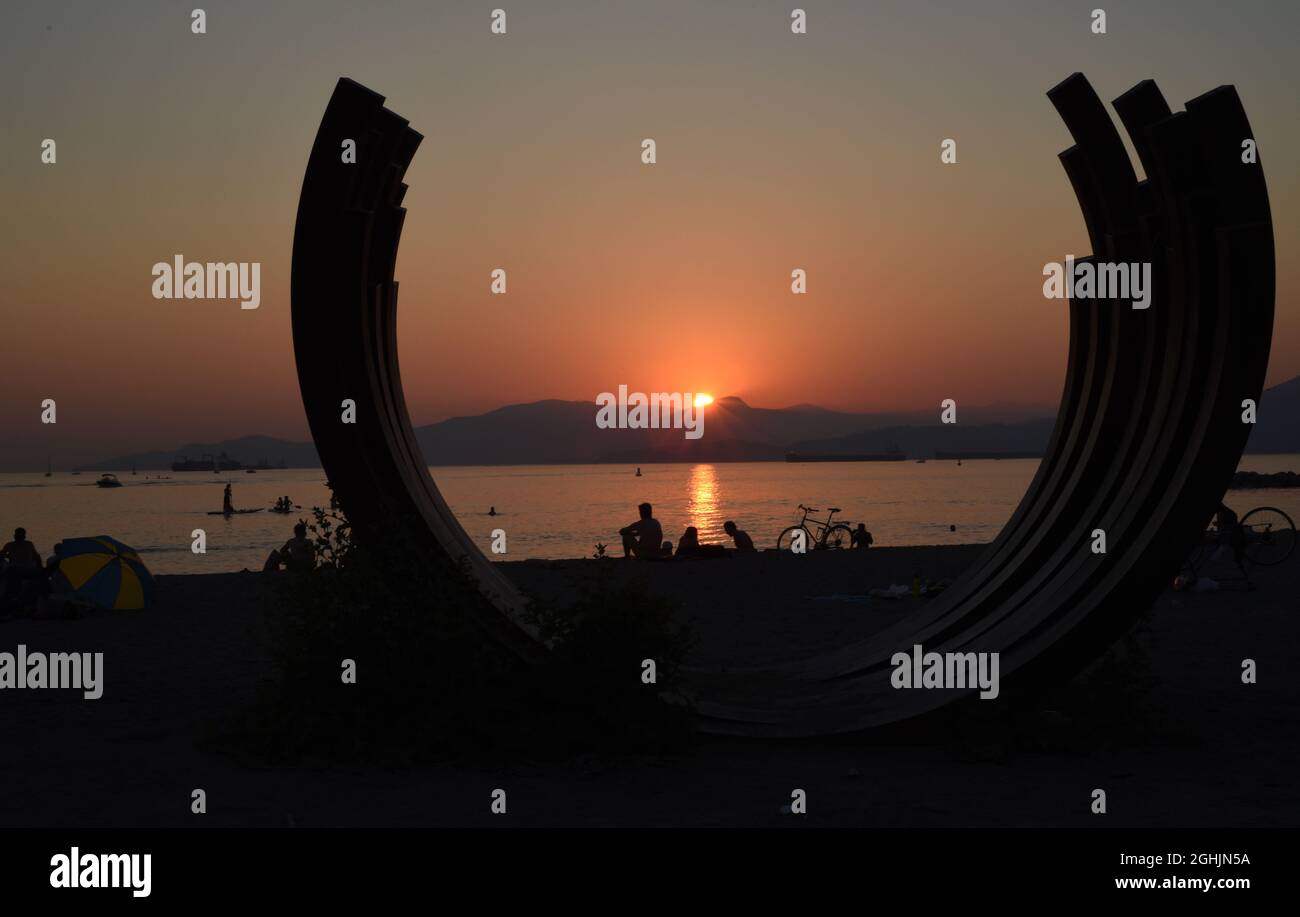 Die Sonne untergeht über der English Bay und eine Silhouette mit dem Namen 217.5 Arc x 3 des französischen Künstlers Bernar Venet am Sunset Beach in Vancouver, British Co Stockfoto