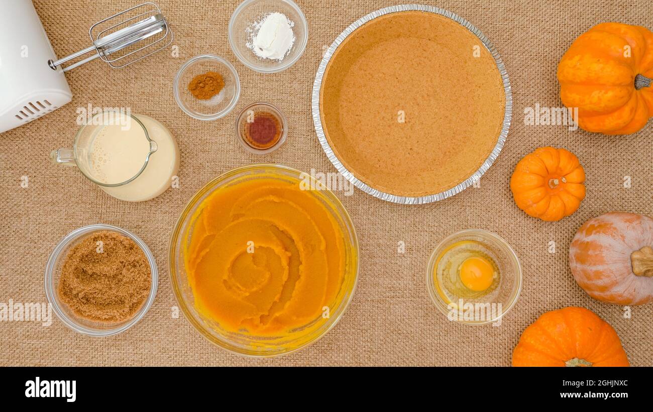 Kürbiskuchen Rezept. Frisches Kürbispüree, Kürbiskruste und Zutaten für Kürbiskuchen hautnah auf rustikalem Hintergrund, direkt von oben Stockfoto