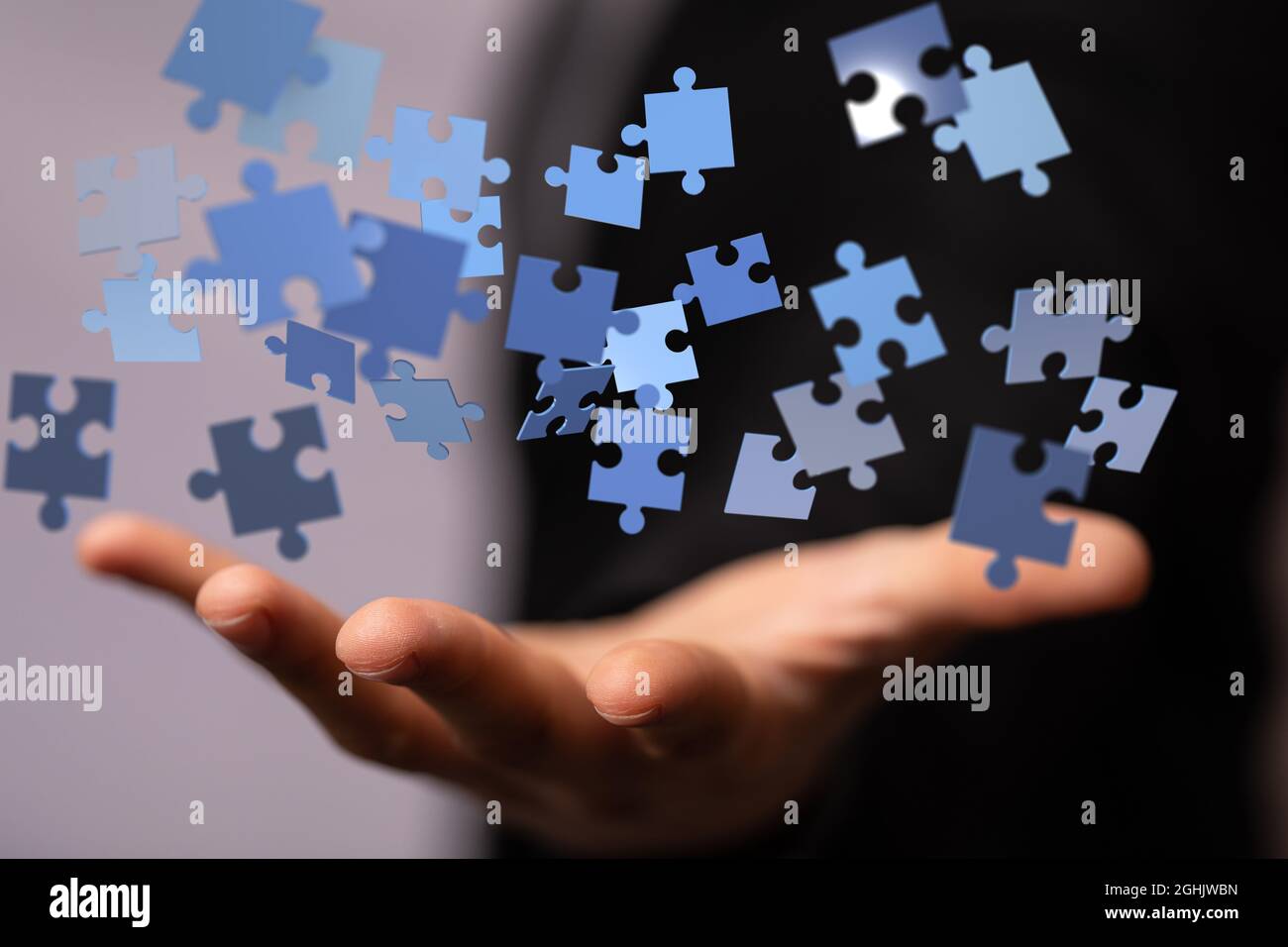 3D-gerenderte Puzzleteile, die über die Hand eines Mannes schweben Stockfoto