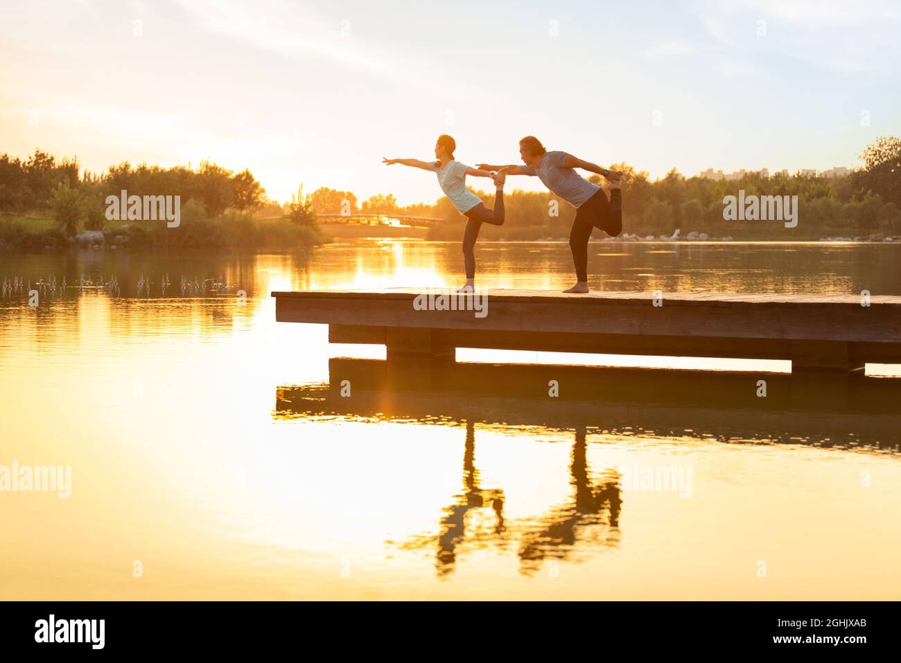 Glückliches reifes Paar, das Yoga im Park macht Stockfoto