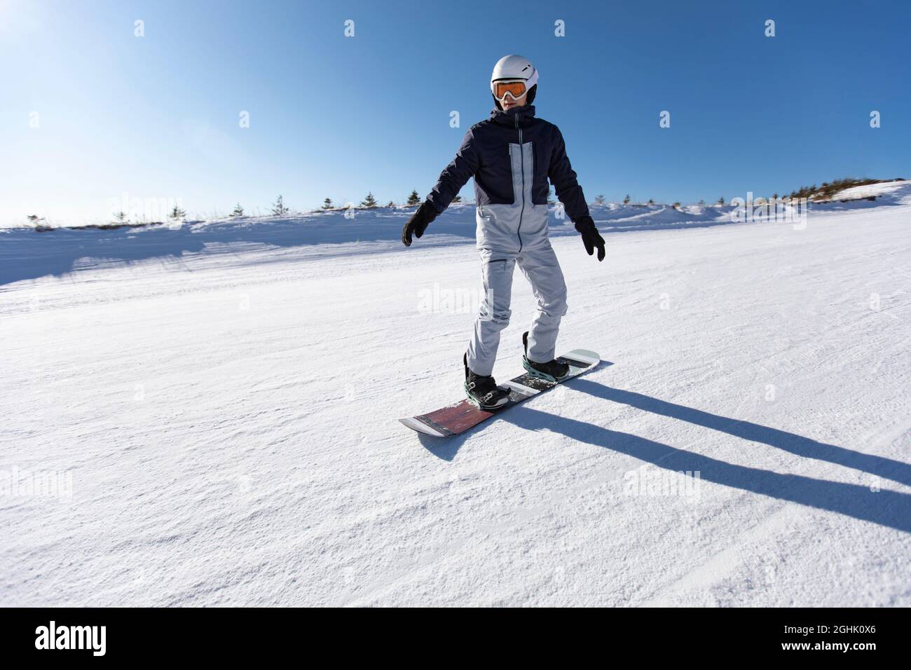 Junger Mann beim Snowboarden im Skigebiet Stockfoto