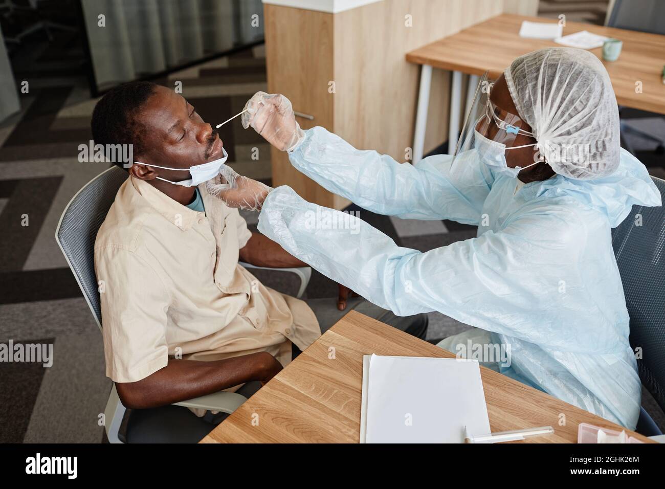 Der Arzt in PSA sammelt Nasenschleim mit einem Tupfer, um auf eine Covid-19-Infektion zu testen Stockfoto