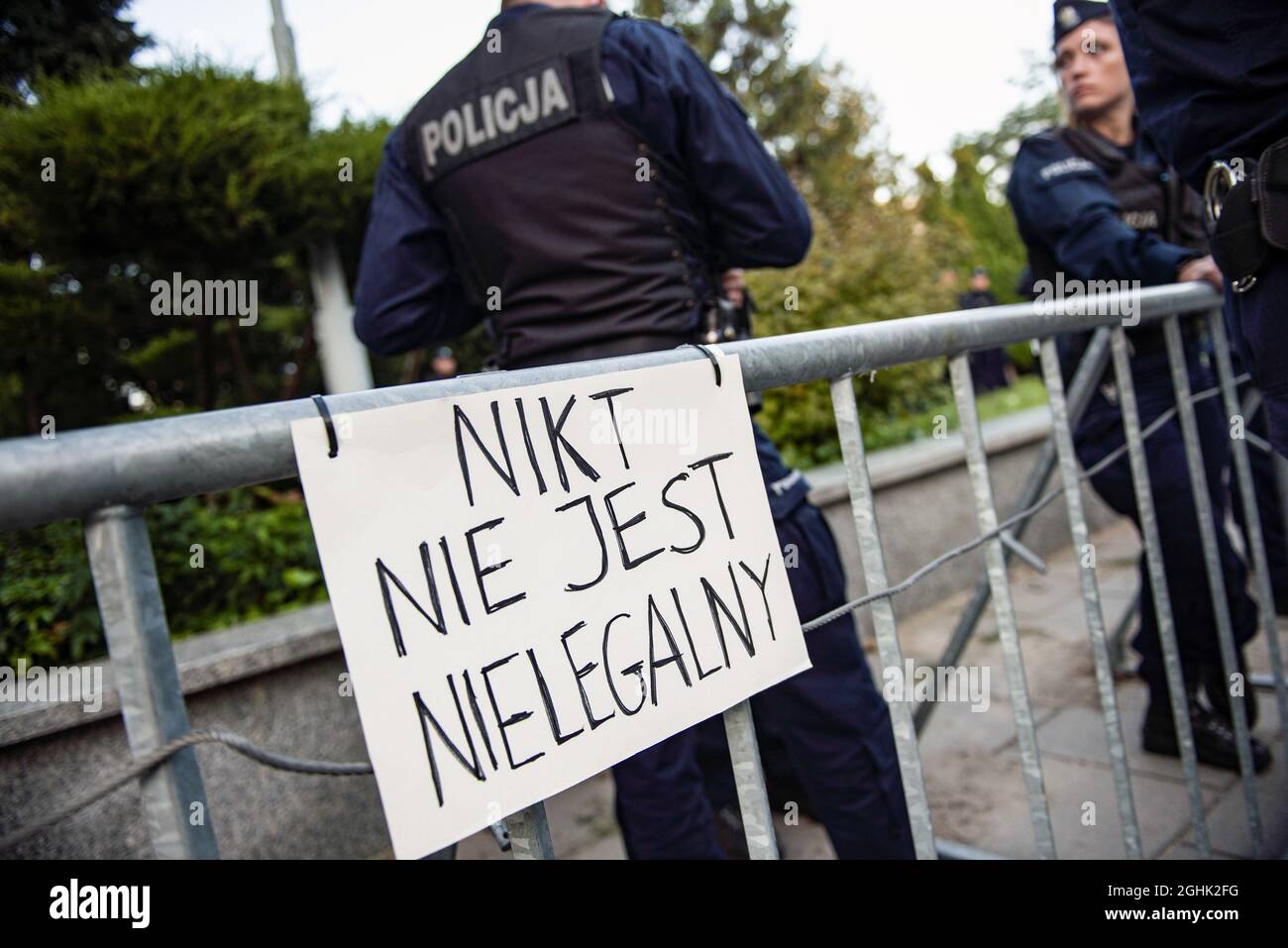 Warschau, Polen. September 2021. Während des Protestes wird ein Plakat mit der Aufschrift "Niemand ist illegal" am Polizeizaun aufgehängt.das polnische Parlament hat heute Abend den Ausnahmezustand in zwei an Weißrussland angrenzenden Regionen offiziell genehmigt - der erste Befehl seiner Art seit den kommunistischen Tagen Polens. Viele der wichtigsten Oppositionsparteien Polens haben den Ausnahmezustand kritisiert und argumentiert, dass es sich um eine Überreaktion handelt, die die bürgerlichen Freiheiten eindämmerte. Kredit: SOPA Images Limited/Alamy Live Nachrichten Stockfoto