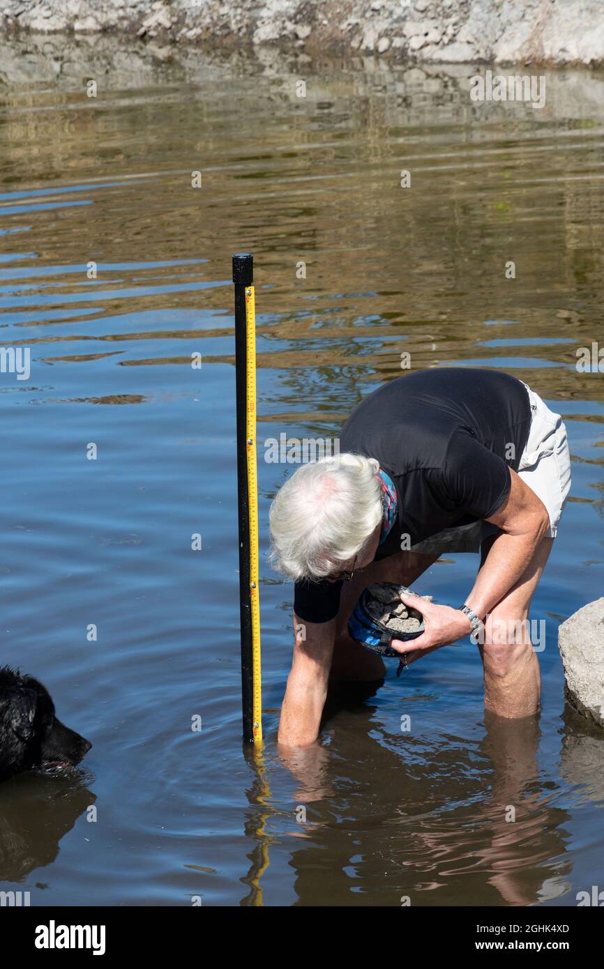 Mann, der eine Wasserstauanzeige in einem kleinen Reservoir in Oregon, USA, installiert Stockfoto