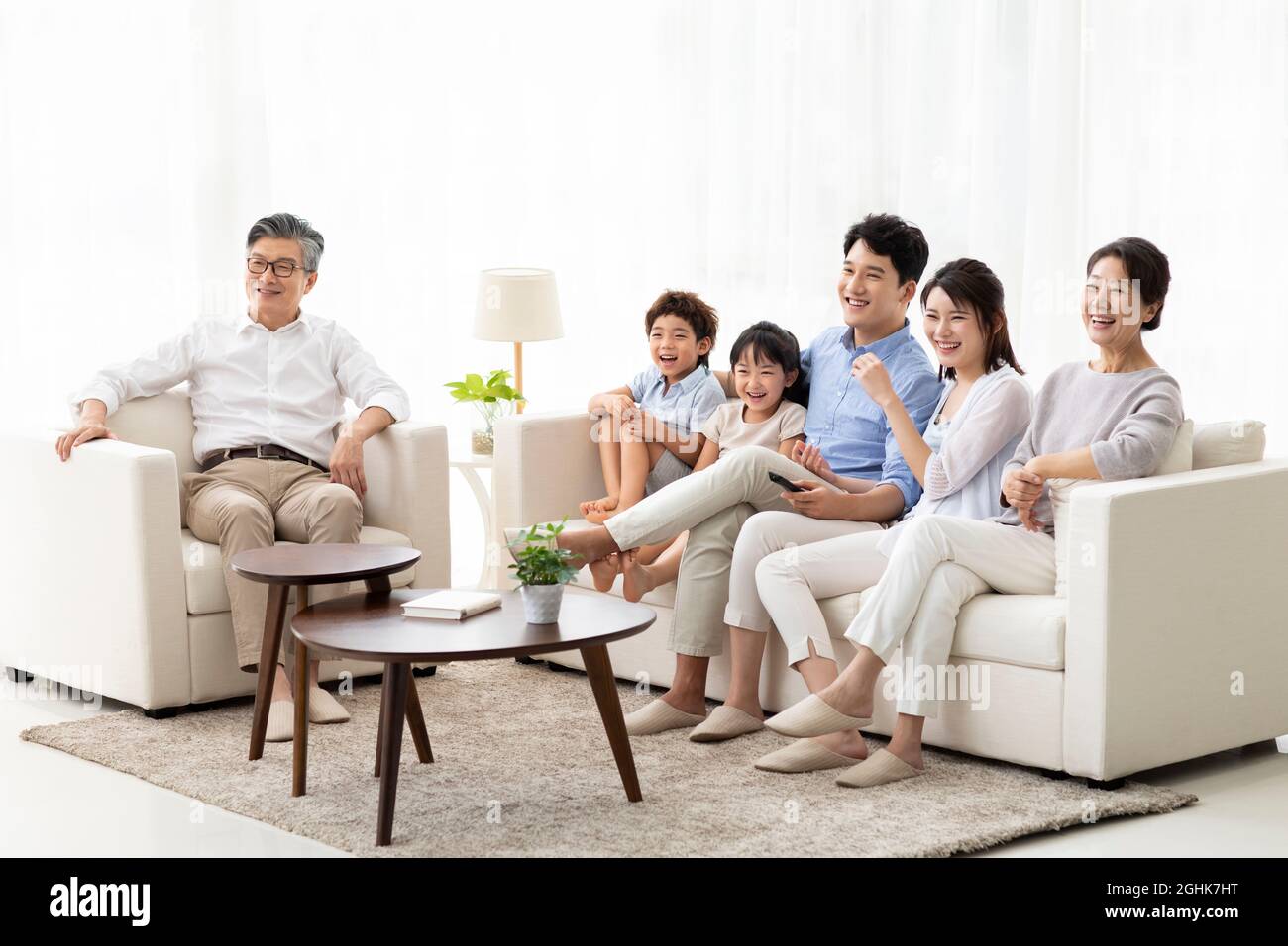 Glückliche Familie vor dem Fernseher zu Hause Stockfoto