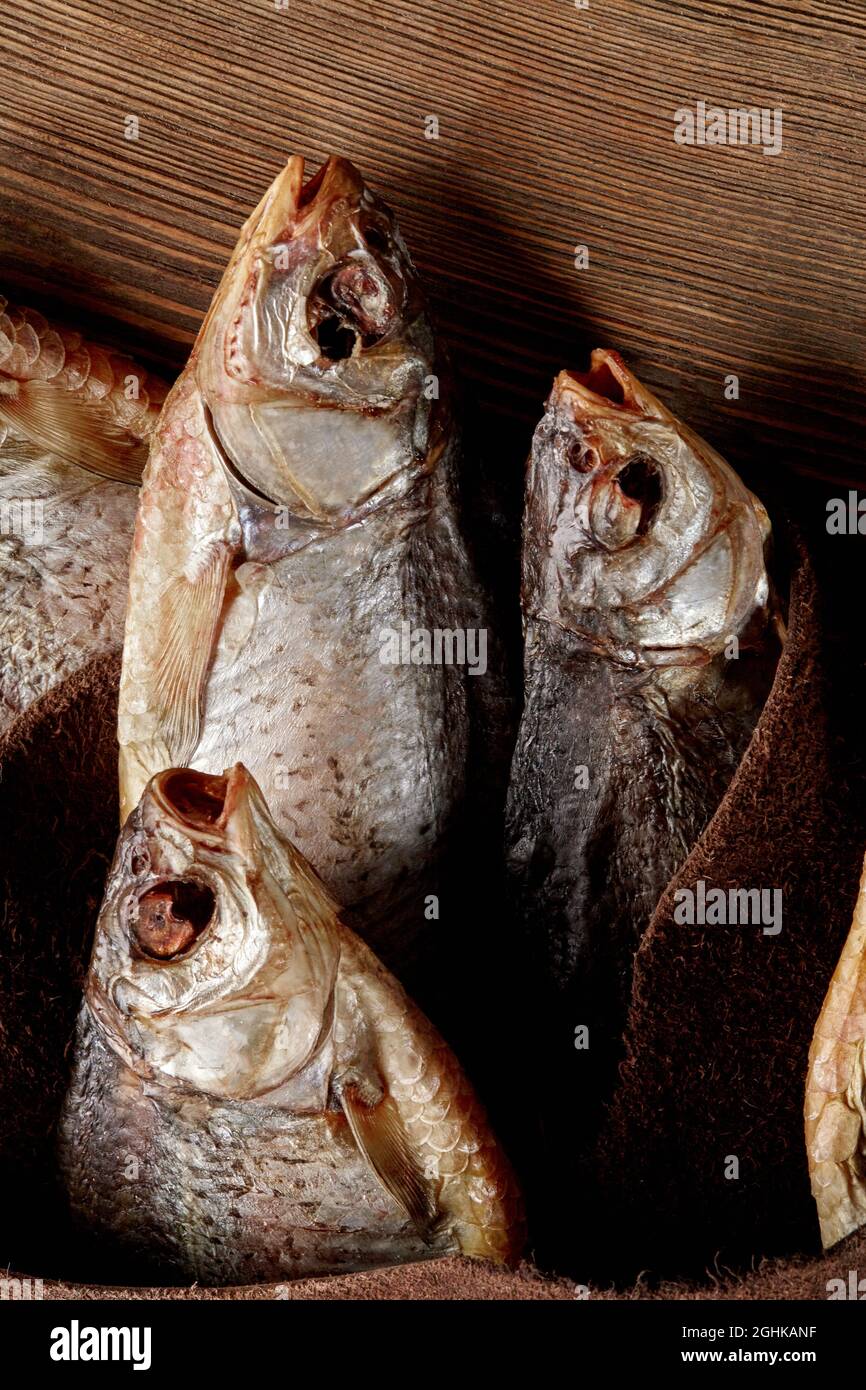 Gesalzener, luftgetrockneter Fisch, eingewickelt in echtem Leder auf Holzhintergrund Stockfoto