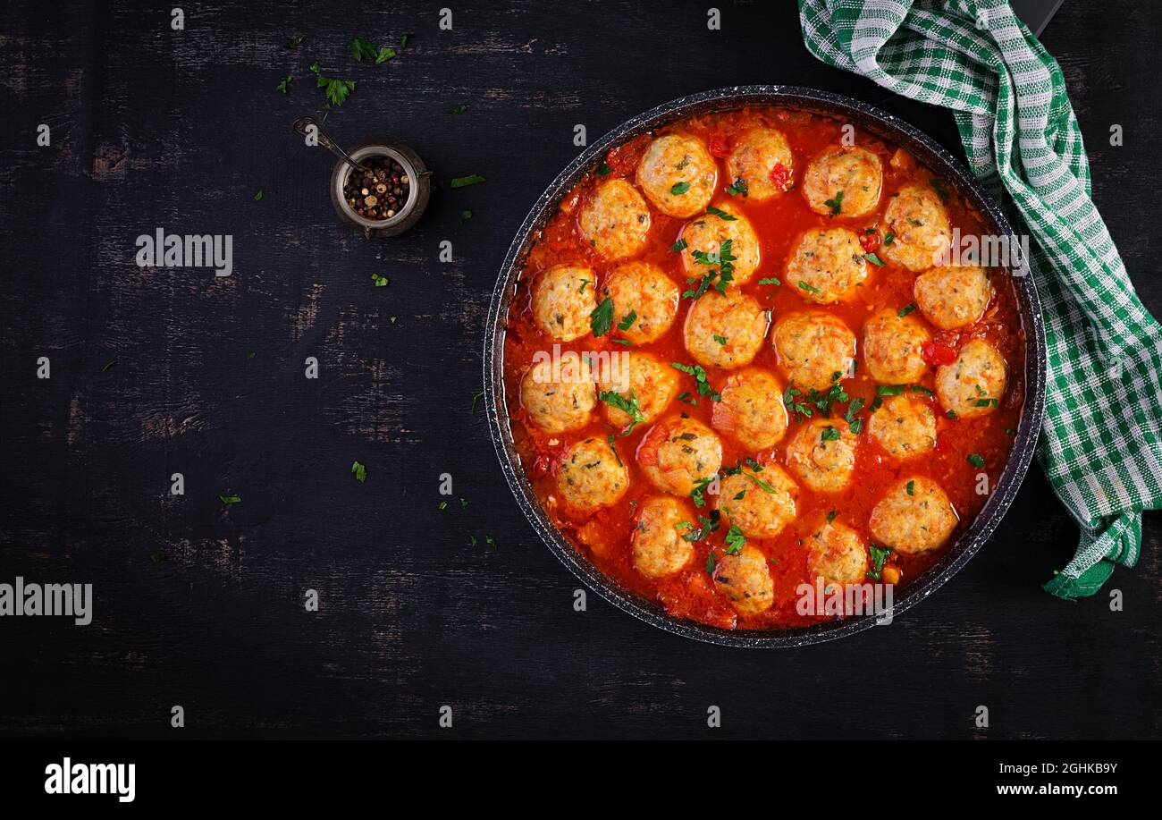Fleischbällchen in Tomatensauce in einer Pfanne auf dunklem Hintergrund. Draufsicht, flach liegend. Stockfoto
