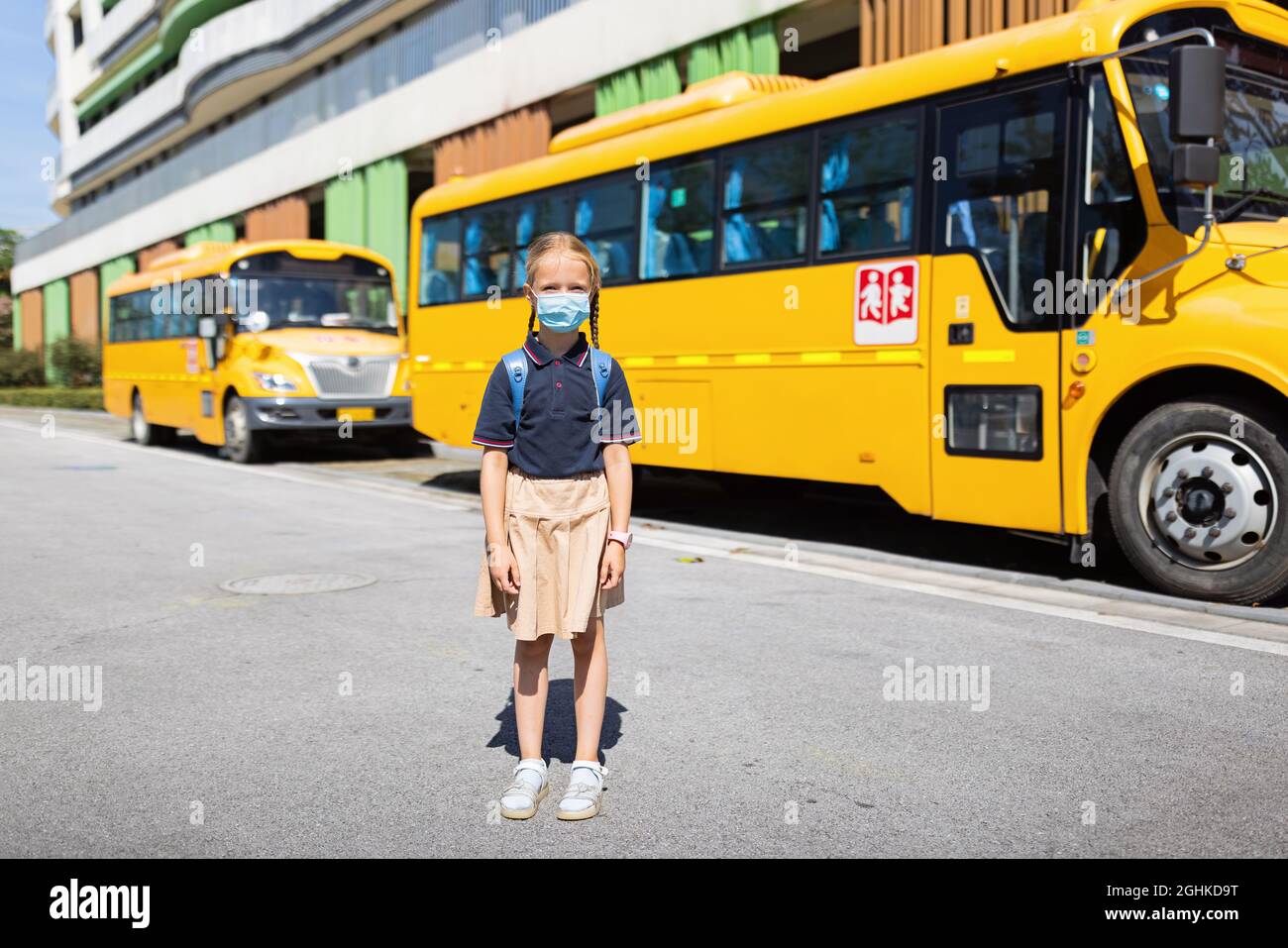 Zurück zur Schule. Kleines Mädchen aus der Grundschule im Freien in der Nähe von gelben Bus. Kinder lernen neue Dinge am 1. september Stockfoto