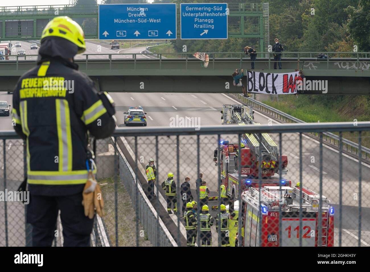 München, Deutschland. September 2021. Aktivisten nehmen an einer Banneraktion auf einer Brücke über die Autobahn A96 bei Gererring Teil. Auf dem Banner steht 'Block IAA'. Die Autobahn wurde in Richtung München gesperrt. Polizei und Feuerwehr sicherten das betreffende Gebiet ab. Kredit: Peter Kneffel/dpa/Alamy Live Nachrichten Stockfoto