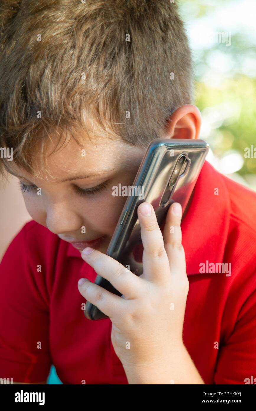 Boy spricht auf dem Smartphone Stockfoto