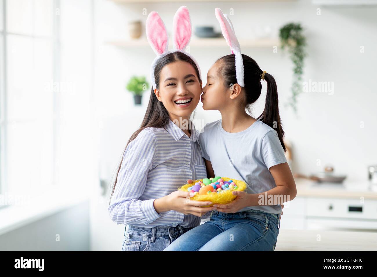 Feiertags- und Feiertagskonzept. Nettes asiatisches Mädchen und eine Frau, die am Ostertag Hasenohren trägt, kopieren Sie den Raum Stockfoto