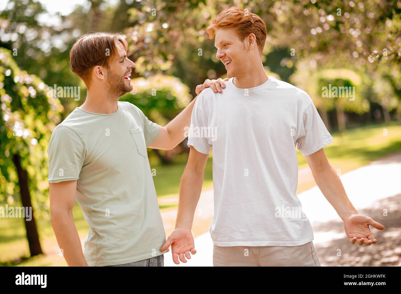 Zwei lächelnde Typen trafen sich im Park Stockfoto